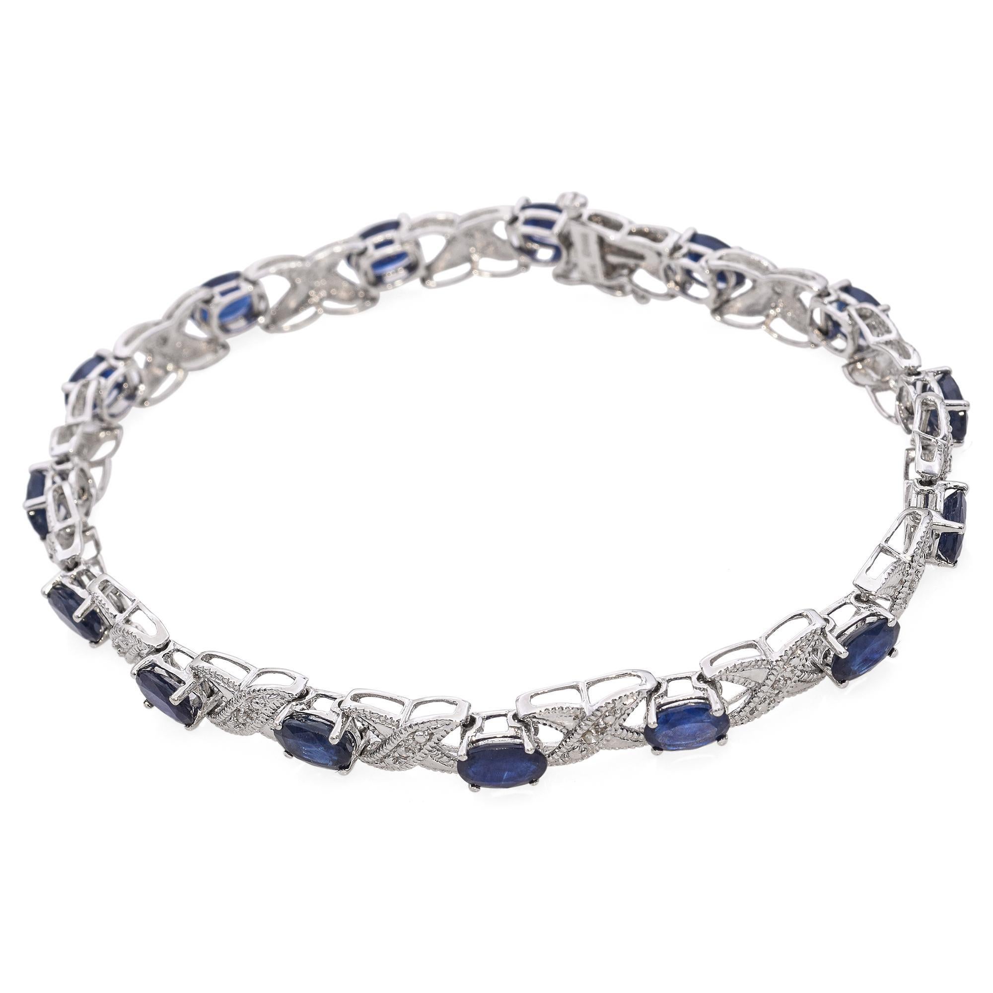 Esta pulsera está elaborada en oro blanco de 14 quilates y presenta una clásica combinación de zafiros azul oscuro y brillantes diamantes. La alternancia de piedras preciosas crea un refinado ritmo de color y luz, engarzadas en eslabones elegantes y