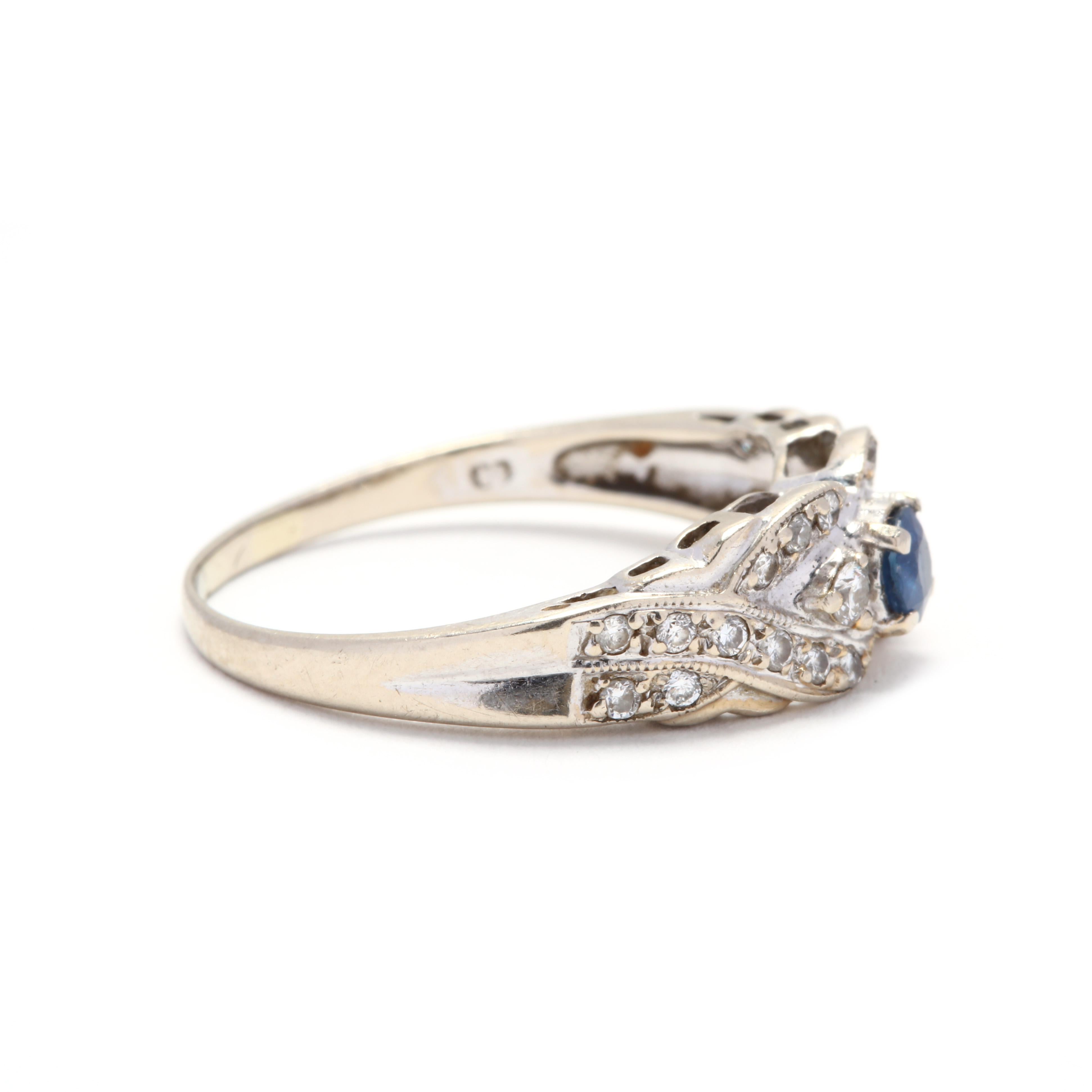 A 14 karat white gold, sapphire and diamond ring. This ring features a prong set, round cut sapphire weighing approximately .21 carat set in a criss cross motif ring with full cut round diamond accents weighing approximately .28 total carats and