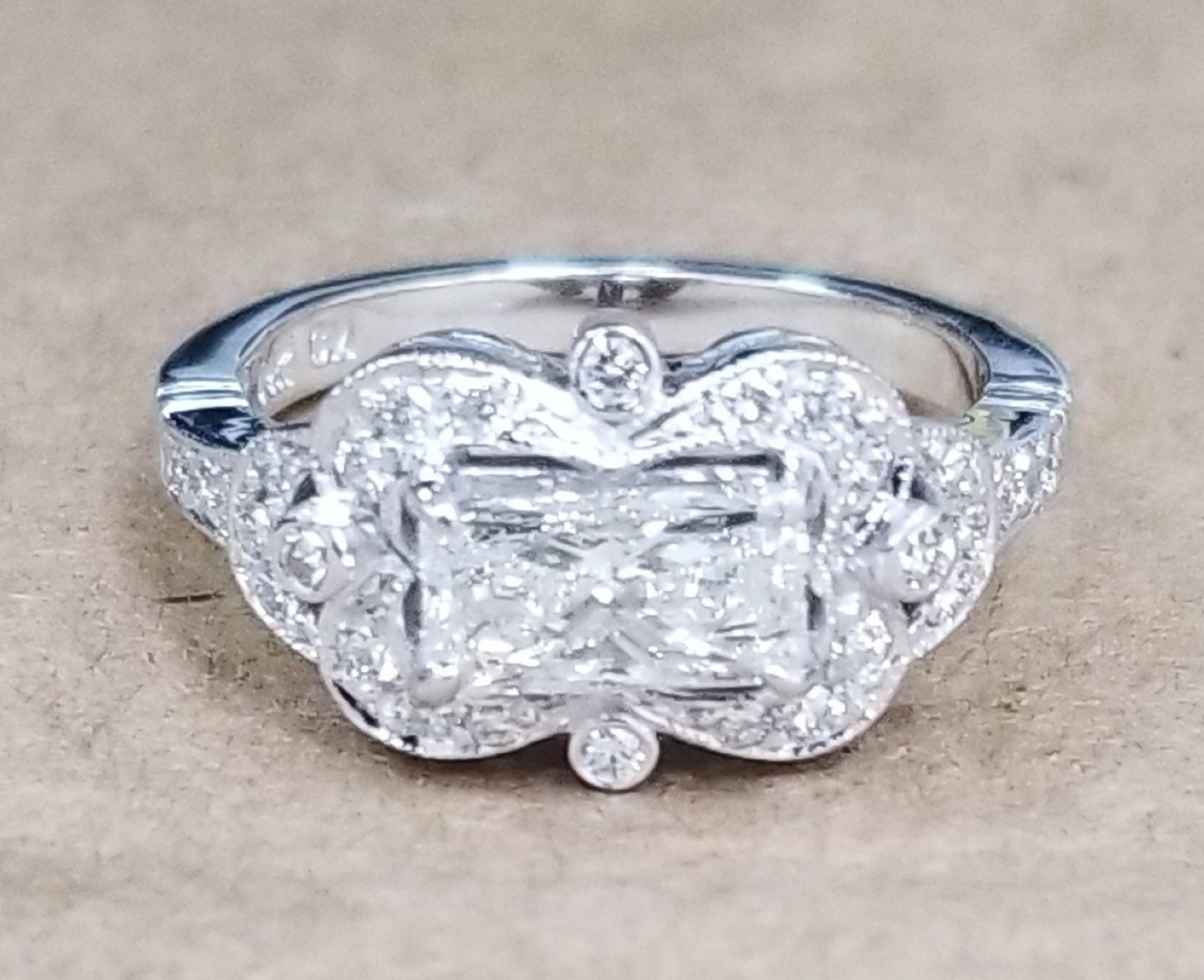 A beautiful 14k white gold setting containing 28 full cut diamonds; color G, clarity VS1 and weight .30pts.  This ring is a size 4.75 but we will size to fit for free. Containing 1 radiant cut diamond color G and clarity SI2 weighing 1.01cts. 

