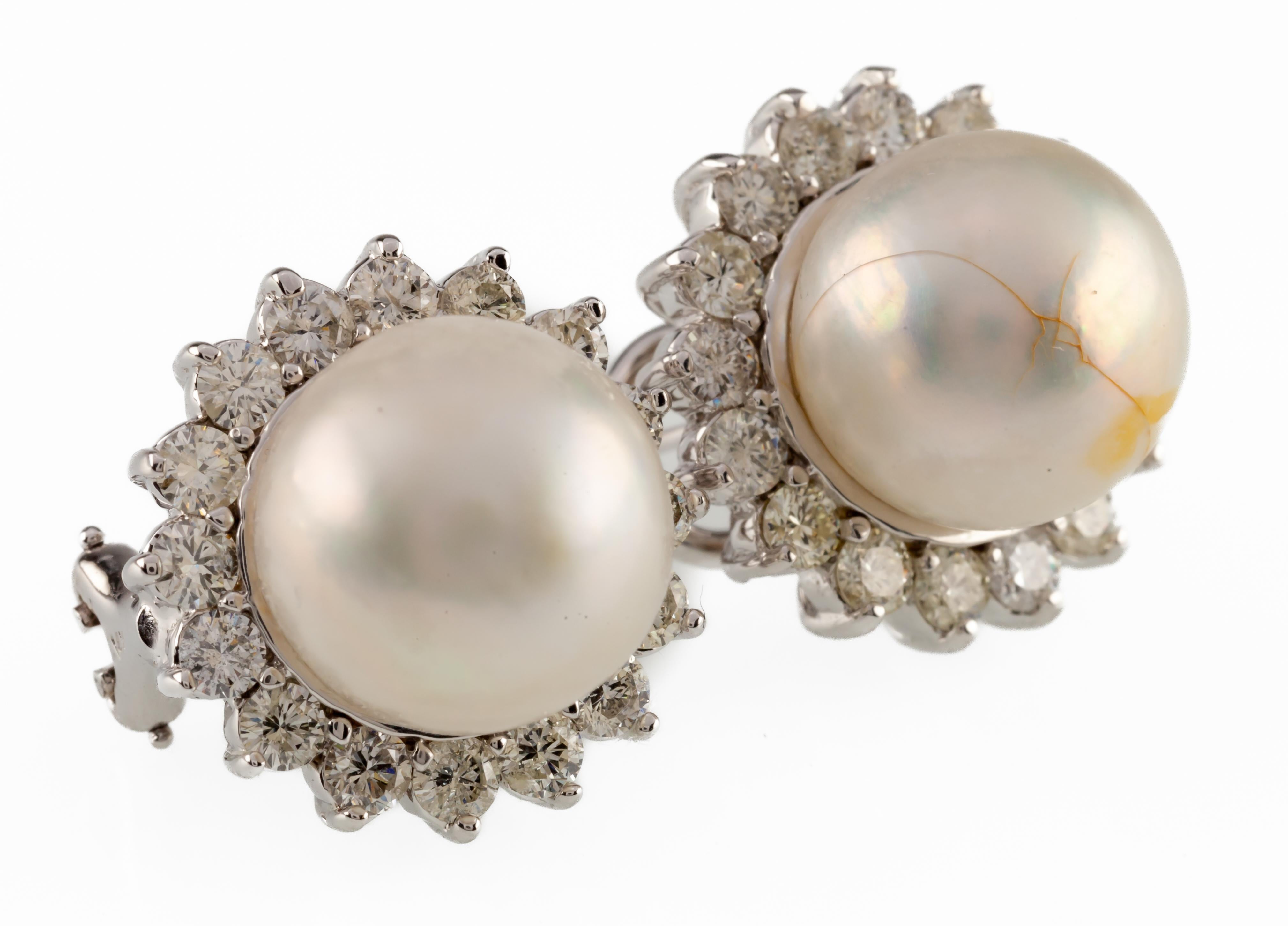 One pair electronically tested 14KT white gold cast & assembled South Sea cultured pearl & diamond earrings with omega backs.
Each earrings features a South Sea cultured pearl set within a gallery of diamonds.
Bright polish finish.
Identified with