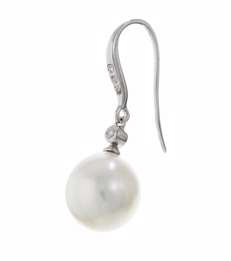 White South Sea Pearl Diamond Drop Earrings

Featuring a pair of beautiful 11mm South Pearls set on a classic 14k white gold diamond accented French hook ear wire.

The pearls are slightly out of round on shape and white in a color with a beautiful