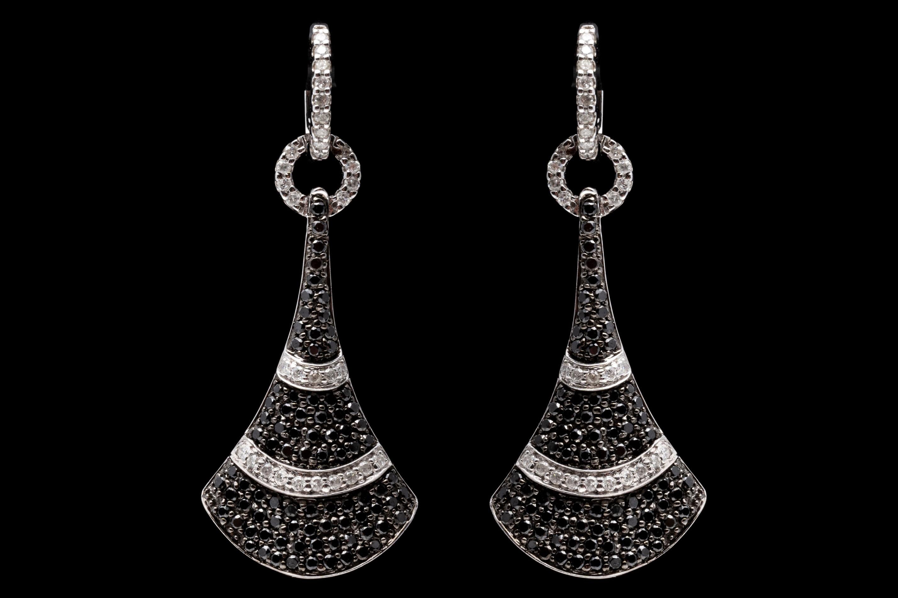 14K white gold and diamond earrings. The flare shaped pendant of these striking earrings is set with black diamond contrasted by two horizontal bands of white diamonds. Approximately 1.94 TCW of diamonds creates a brilliant shimmer. Post and leaver