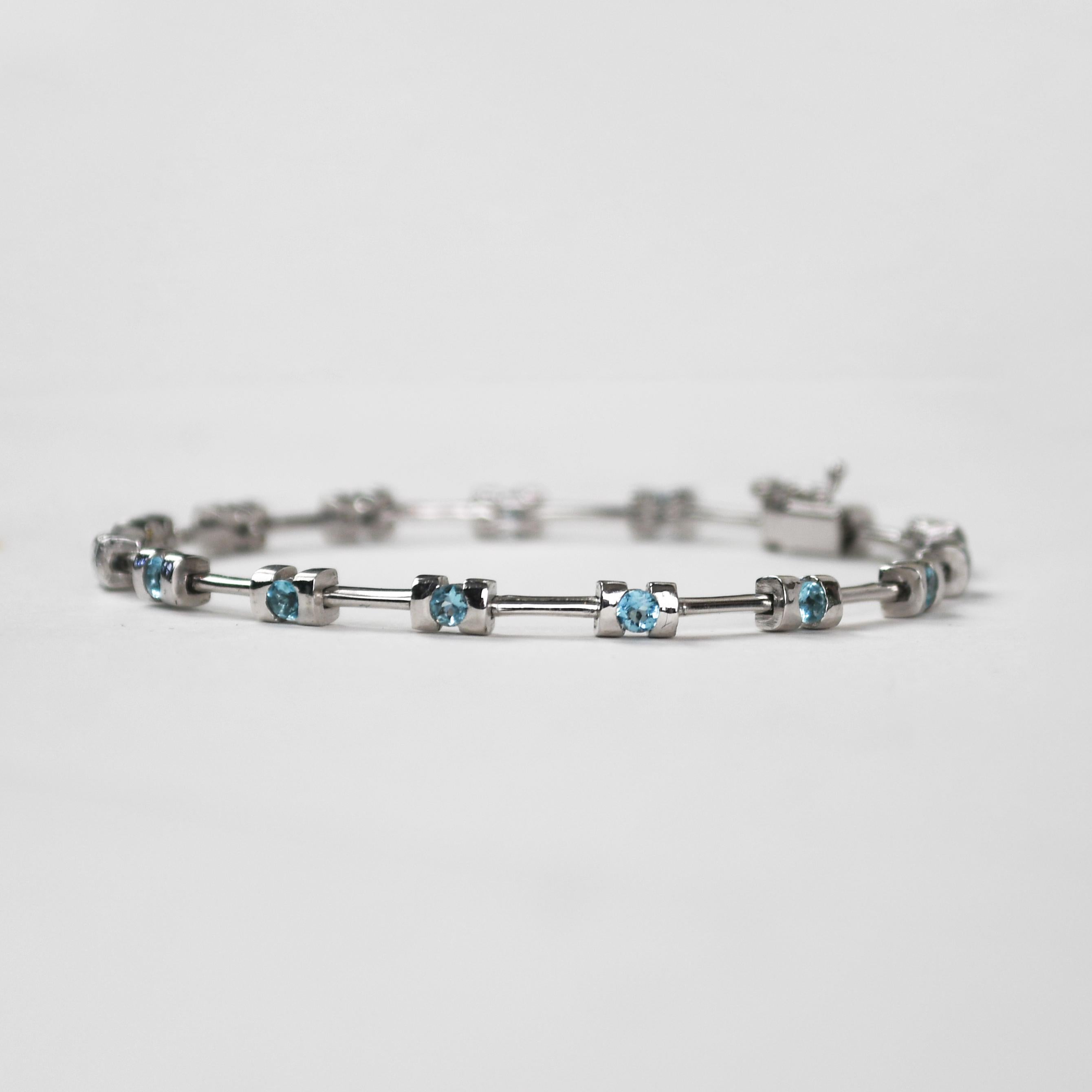 Ladies' 14k white gold bracelet with synthetic blue stones.
Stamped Italy 14k and weighs 13.8 grams gross weight.
There are round brilliant cut blue stones between the links.
The bracelet measures 7 1/2 inches long and 4mm wide at widest