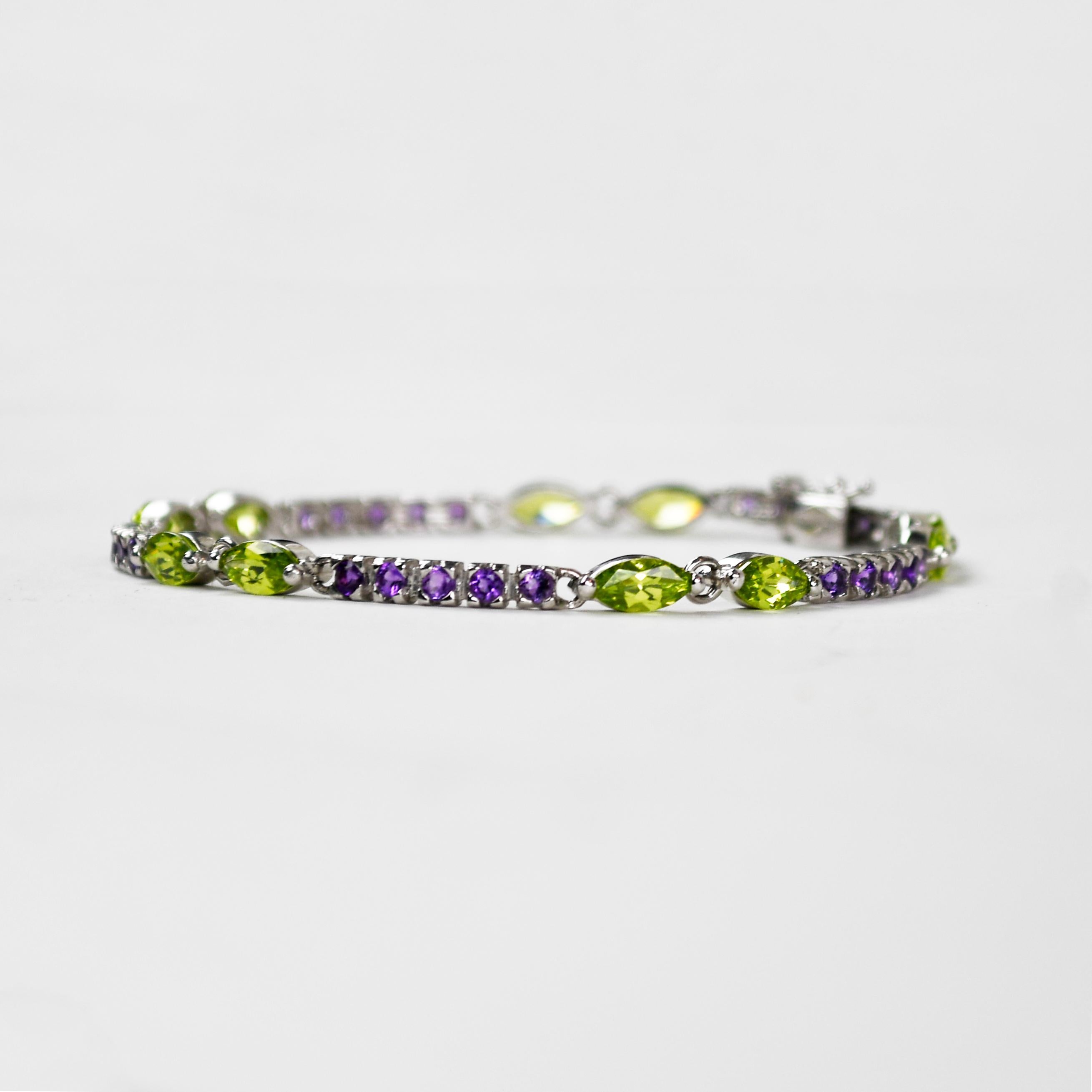 Bracciale da donna in oro bianco 14k con ametista e peridoto sintetico. 
Timbrato 14k Italia e pesa 10,7 grammi.
Ci sono 10 pietre di peridoto sintetico a forma di marquise, per un totale di circa 3,00 carati.
In mezzo ci sono ametiste rotonde