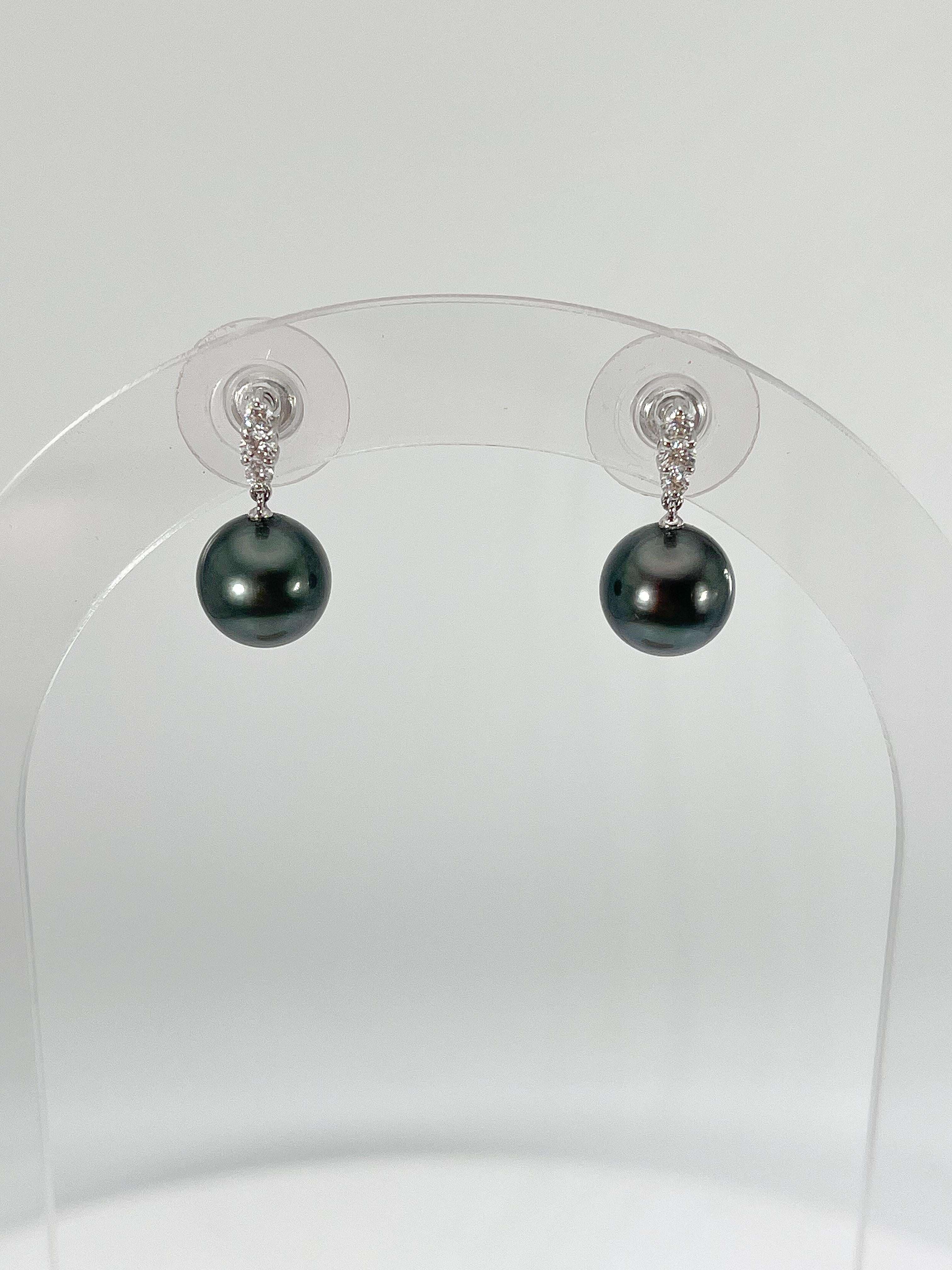 14k white gold Tahitian pearl and .15 CTW diamond earrings. The diamonds in these earrings are all round, the length of these earrings are 17.3 mm, they have a width of 9 mm, and they have a total weight of 3.07
