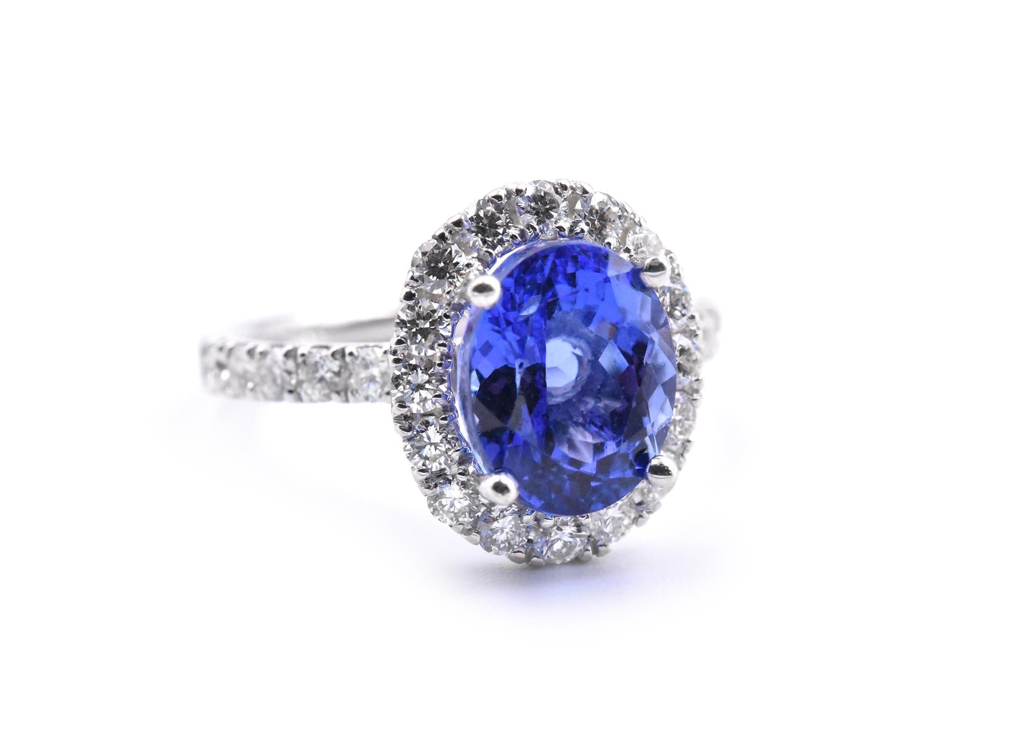 Designer: custom 
Material: 14k yellow gold
Tanzanite: 1 oval cut tanzanite = 3.28ct
Diamonds: 28 round brilliant cuts = 0.87cttw
Color: G-H
Clarity: VS2
Ring Size: 6 ½ (please allow two additional shipping days for sizing requests)
Dimensions: ring