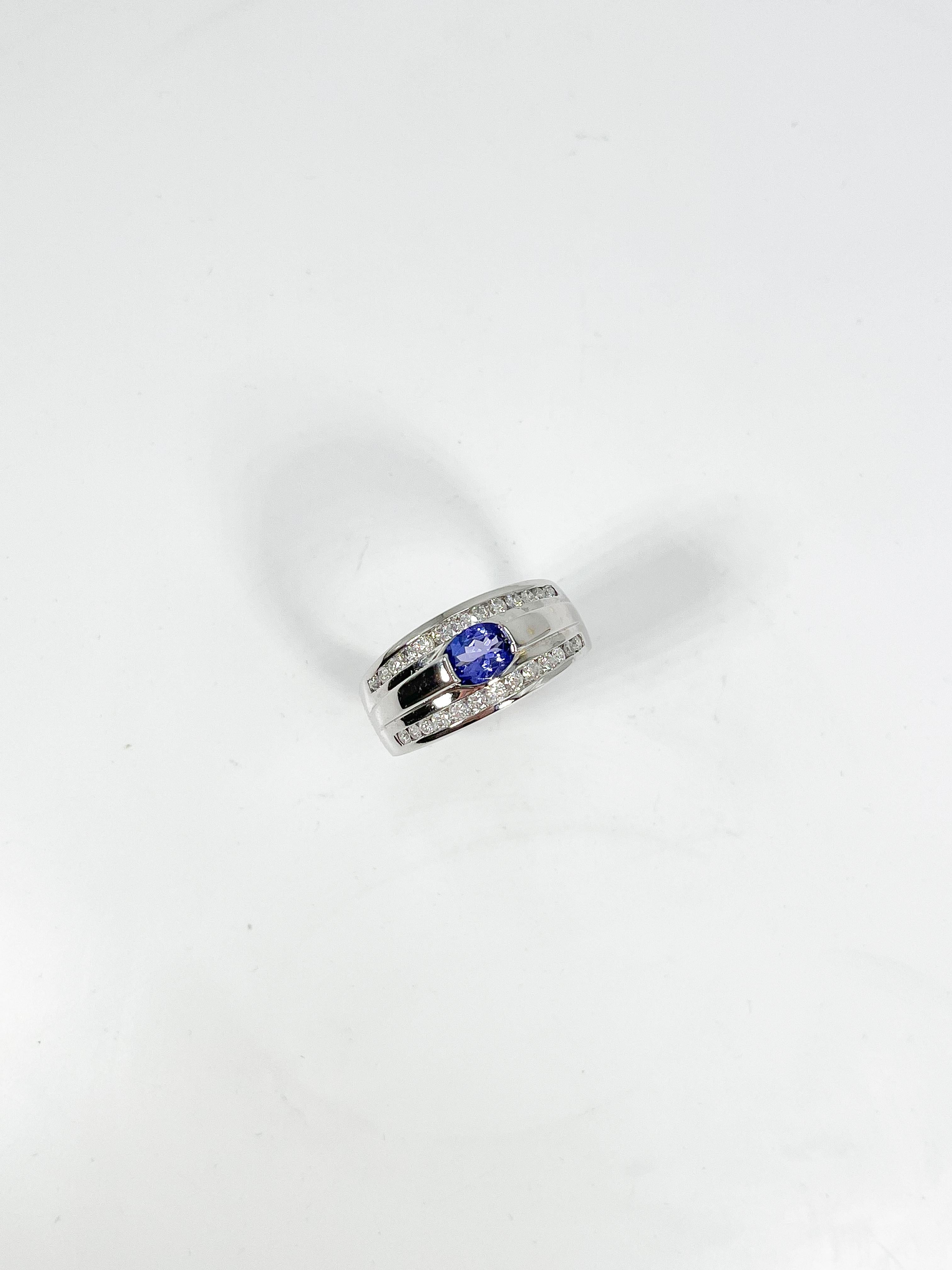 14k white gold tanzanite and diamond ring. Tanzanite stone is oval cut, the diamonds are all round, the width of the ring is 10 mm, the ring size is a 7, and it has a total weight of 9.46 grams.