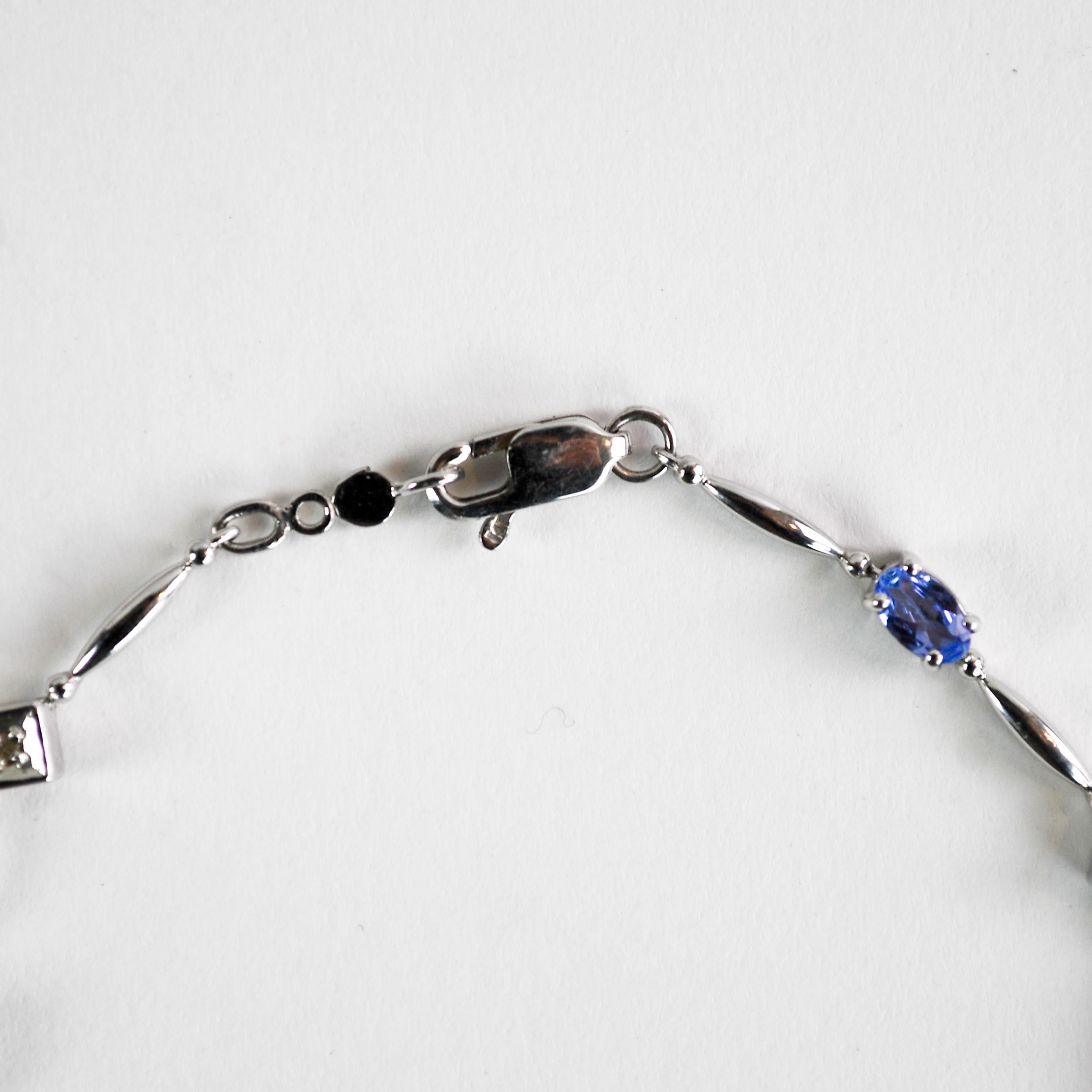 14k white gold tanzanite and diamond bracelet.
Tests 57% gold using a XRF metals analyzer.
Weighs 5 grams.
The tanzanite stones are oval shape, pale violet, 1.00 total carats.
In between the tanzanite stones are five tiny round diamonds.
The