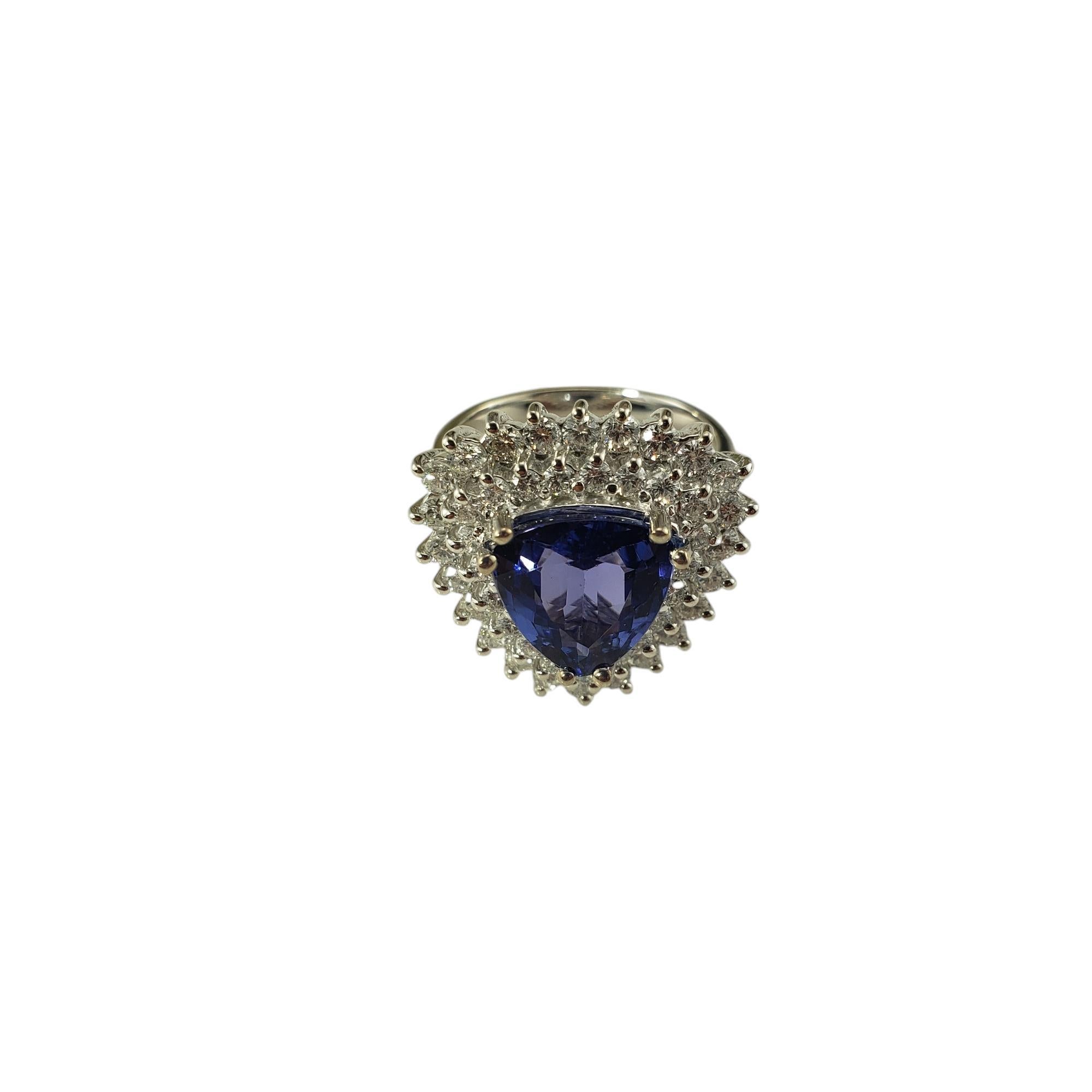 Anello da cocktail con tanzanite e diamanti in oro bianco 14 carati, misura 6,5, certificato JAGi.

Questo spettacolare anello in oro bianco 14K presenta una tanzanite a forma di triangolo circondata da 45 diamanti rotondi a taglio brillante in una
