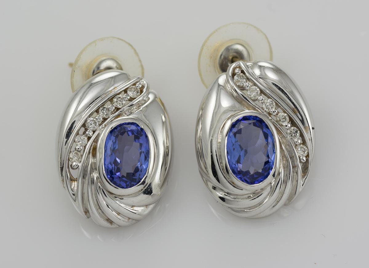 Orecchini di tanzanite in oro bianco 14k con diamanti.
Gli orecchini sono da 14k, ma non sono contrassegnati e pesano 9,7 grammi.
Le pietre centrali sono due tanzaniti ovali, per un totale di 3,00 carati, con un bel colore bluastro-violetto.
Ai
