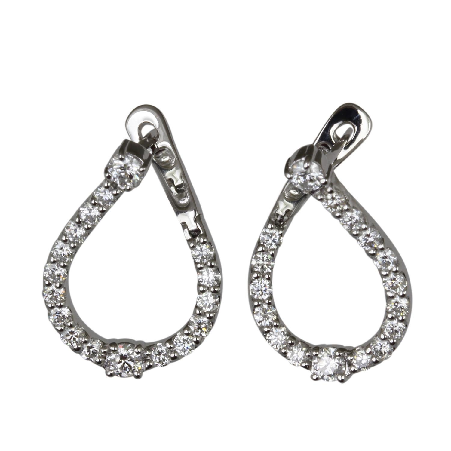Sparkling like stars in the night sky, diamonds gracefully descend on teardrop-shaped hoops, meticulously crafted from your choice of 14K yellow or white gold. These earrings are designed to enhance your natural radiance, adding a touch of allure to