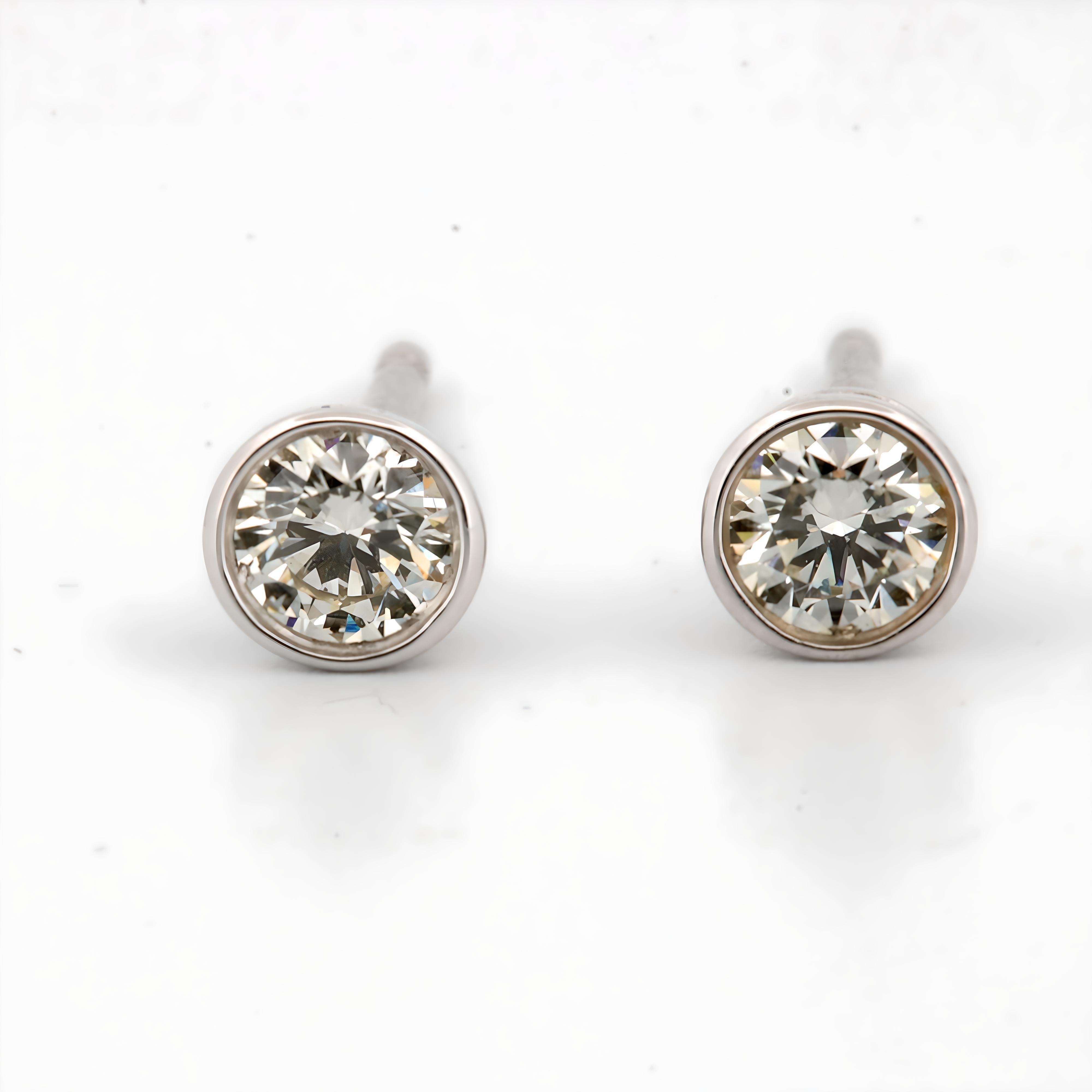 These stunning earrings are crafted from luxurious 14K white gold, exuding a timeless elegance that is both modern and classic. Each earring is set with a brilliant round-cut natural diamond, totaling 0.10 carats across the pair. The diamonds are