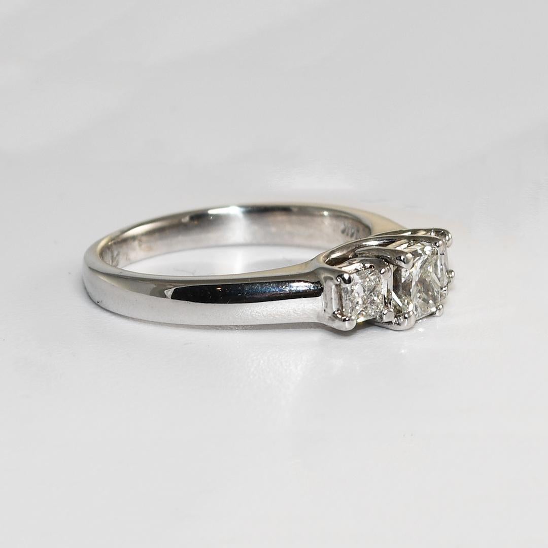 Bague de fiançailles en diamant en or blanc 14k.
Il est marqué 14k et pèse 4,7 grammes.
Le diamant central est une taille princesse de 0,65 carat, de couleur i, j, k et de pureté si.
Les deux plus petits diamants de taille princesse pèsent 0,23ct et