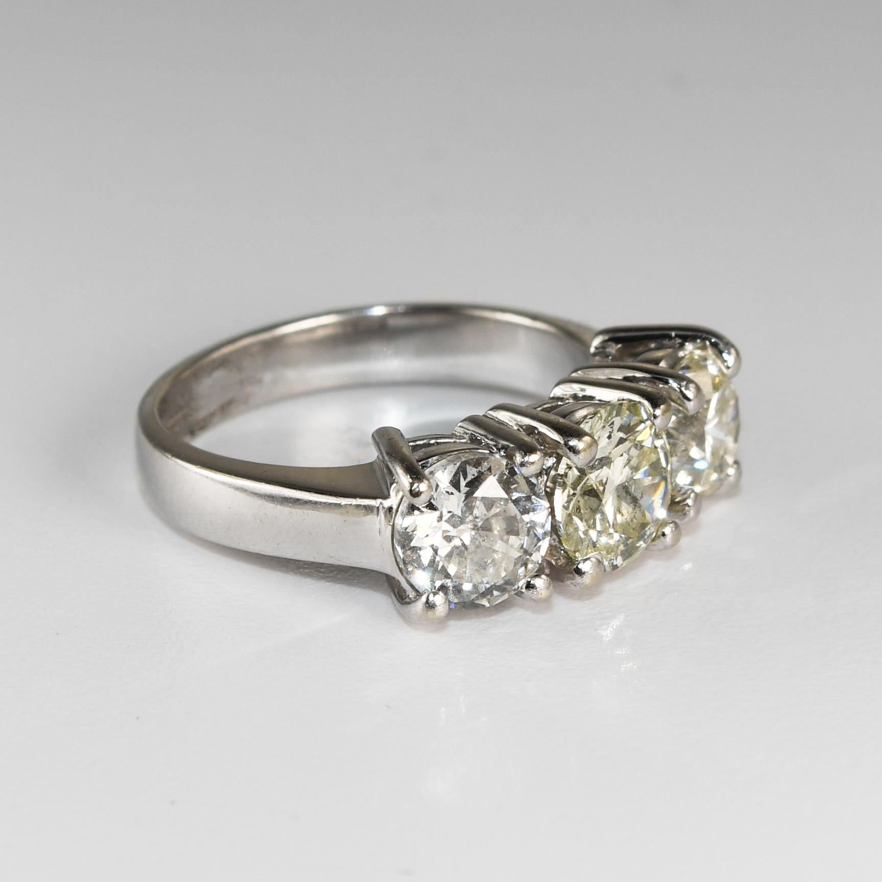 Anello a tre diamanti con montatura in oro bianco 14k.
Timbrato 14k e pesa 5,9 grammi.
Ci sono tre diamanti rotondi taglio brillante, uno da 1,00 carati di colore da L a M, purezza I1, taglio buono, uno da 0,95 carati di colore da I a J, purezza SI,