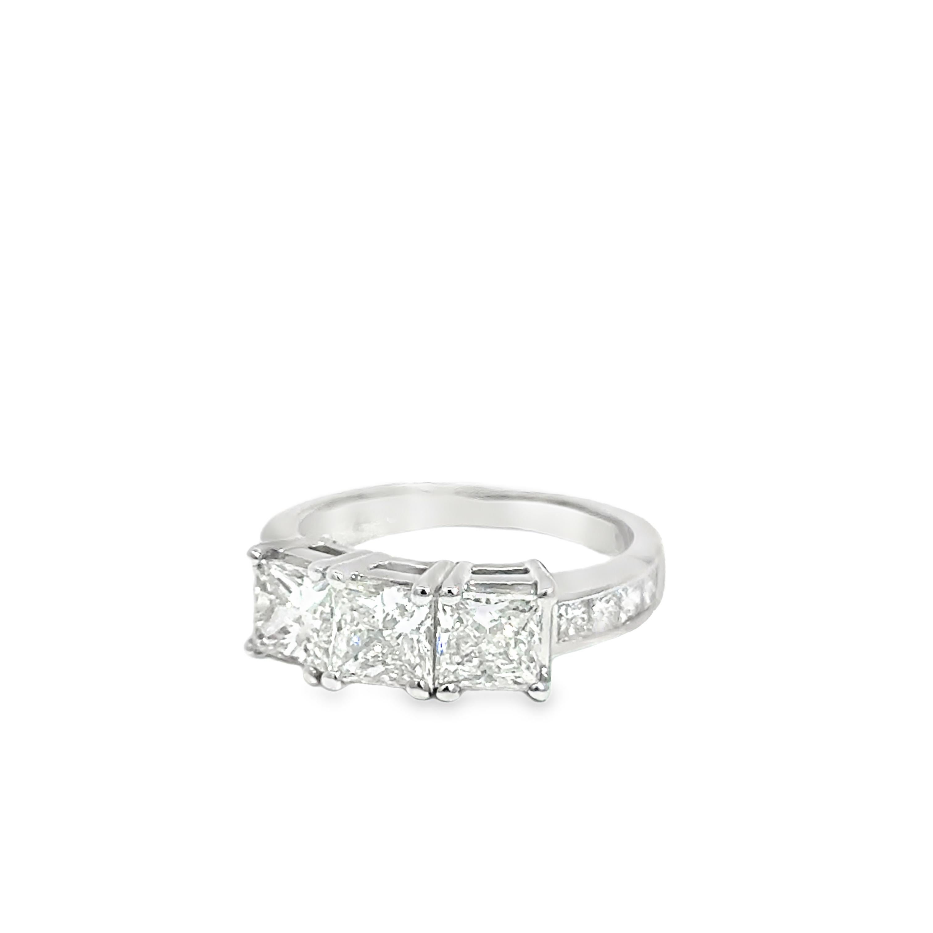 Ein eleganter und moderner Ring aus 14 Karat Wei�ßgold mit einem atemberaubenden zentralen Diamanten im Prinzessinnenschliff von 2,05 Karat, flankiert von zwei kleineren Diamanten im Prinzessinnenschliff von insgesamt 0,46 Karat. Das Design betont