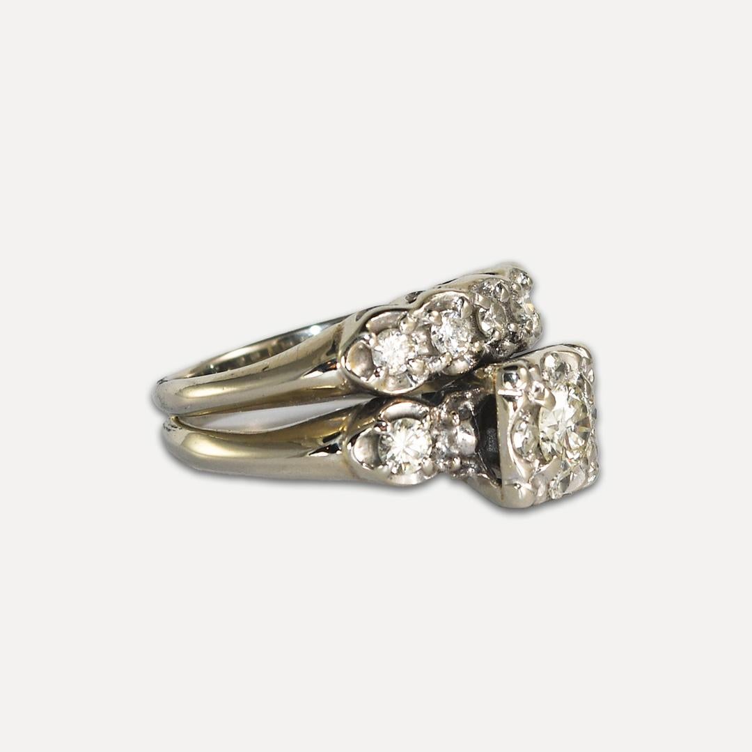 This vintage 14-karat white gold ring weighs 6 grams.
It contains a solitaire round brilliant diamond, with a carat weight of 0.32
It is accented by seven more round brilliant diamonds, with a total carat weight of 0.33.
Each diamond averages, j, k.