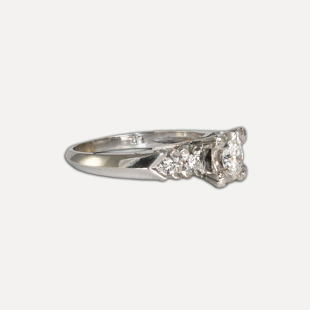 Ladies' vintage diamond ring with 14k white gold setting.
Stamped 14k and weighs 3.3 grams gross weight.
The center diamond is a round brilliant cut, .30 carats, H to I color, and Si1 clarity.
The side diamonds are round brilliants, .10 total