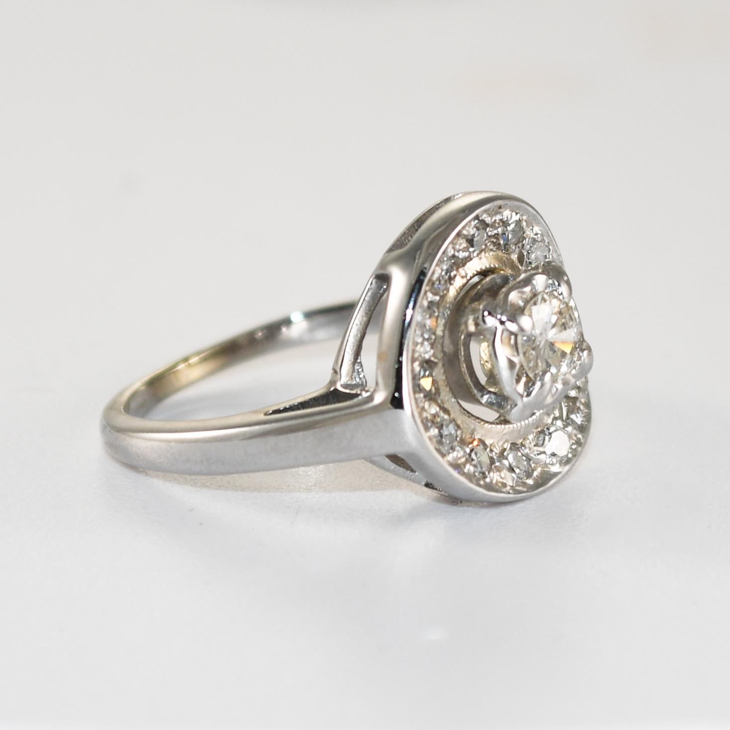Anello vintage da donna in oro bianco 14k e diamanti.
L'anello è al 56,5% di oro e pesa 4,5 grammi.
Il diamante centrale è un taglio brillante rotondo da 0,20 carati, colore J e purezza Si2.
I diamanti laterali sono rotondi, taglio singolo, 0,25