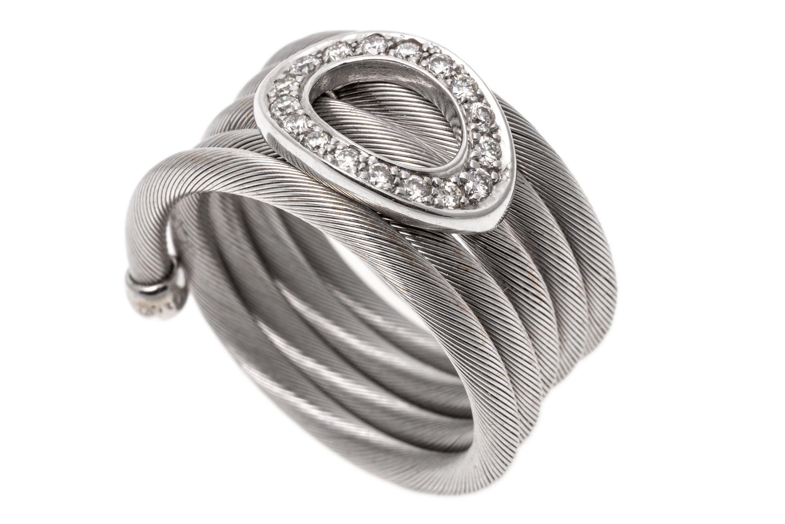 14k white gold ring. This unusual ring is wide, with five rows of finely ribbed, flexible coils, decorated in the center with an open oval, set with round faceted diamonds, approximately 0.17 TCW, prong set. The ring is finished with high polished