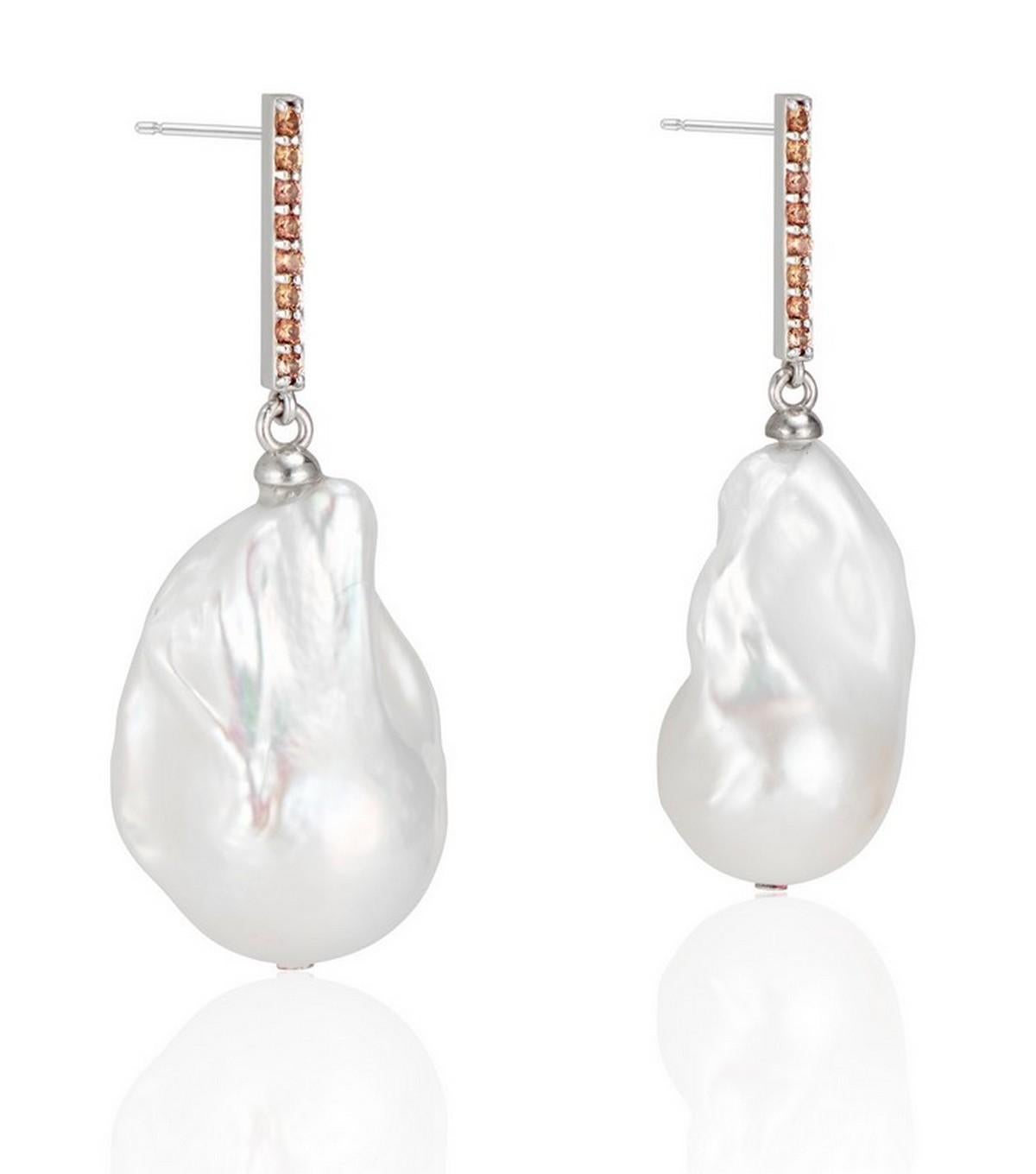 14K Vertical Gold Bar with a beautiful soft shade of orange sapphire and baroque pearl drop earring.
The hue of orange sapphire against the high polish white gold contrasts beautifully with the pearl, and the shimmering vertical bar gives the