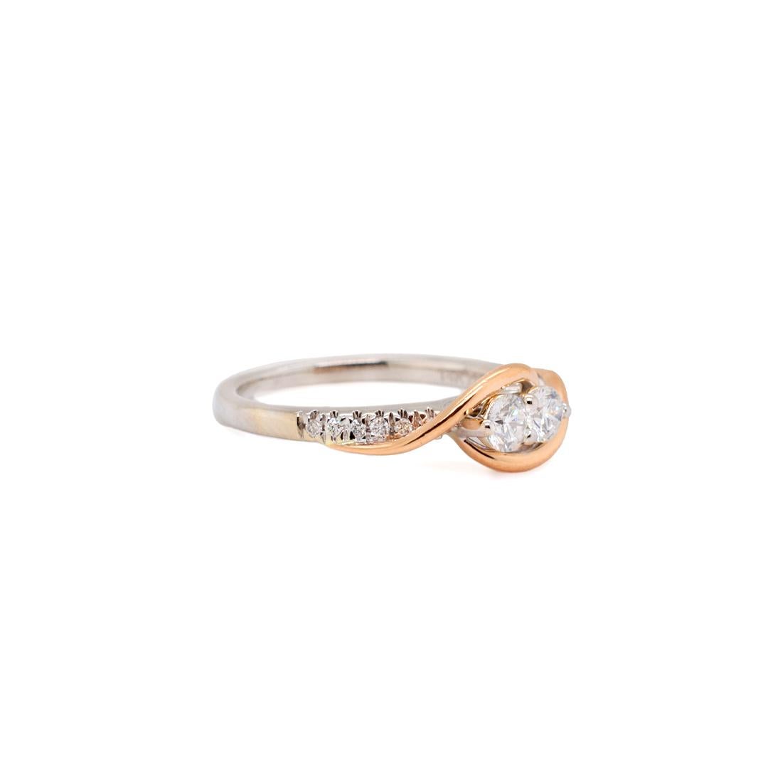 One ladies custom made polished, 14K white gold and 14K rose gold two-stone, diamond engagement, wedding ring with a bypass shank. The ring is a size 7, is 1.36mm thick and measures approximately 2.06mm tapering to 1.72mm in width and weighs a total