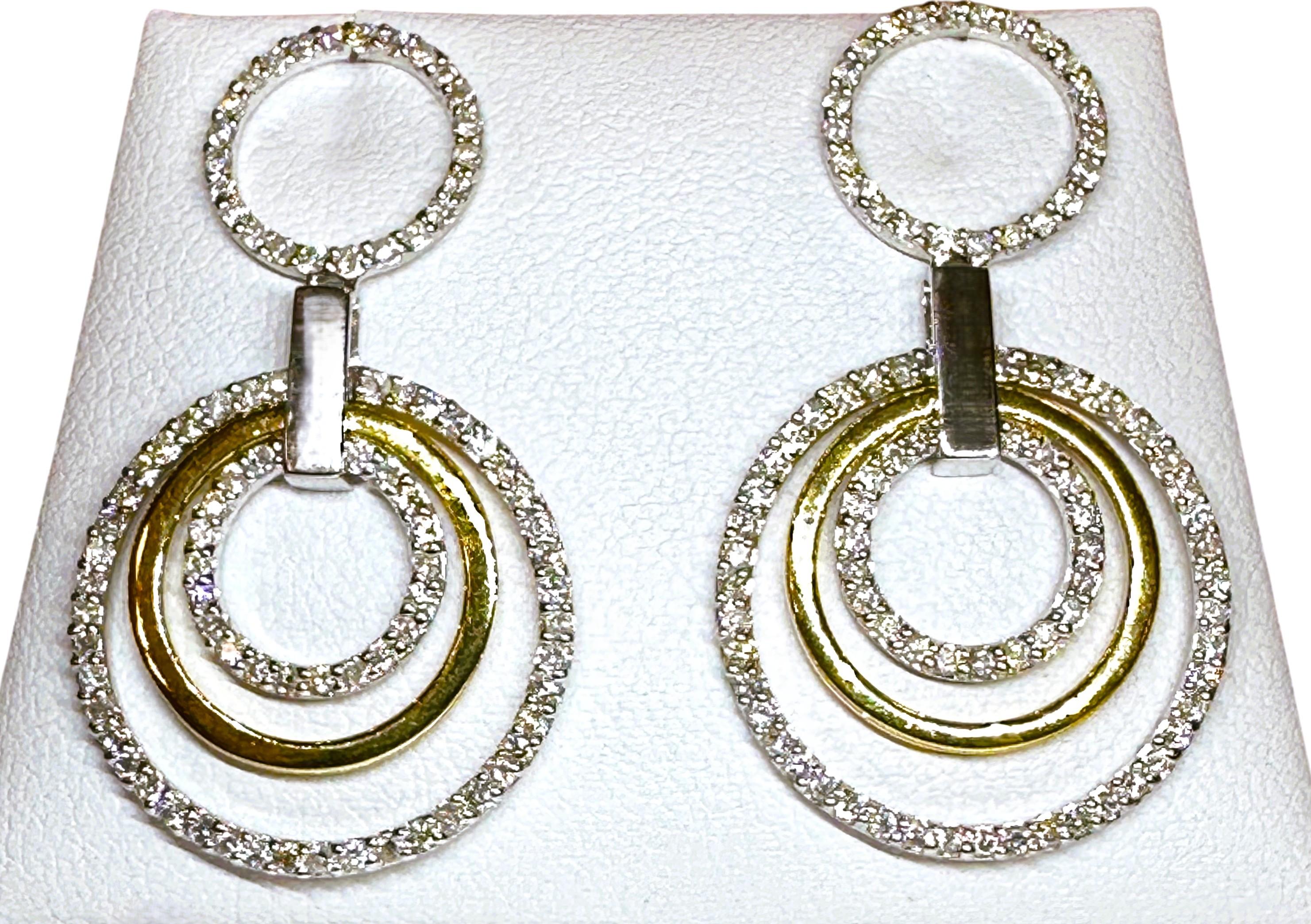 Ces boucles d'oreilles sont tout simplement magnifiques !  Elles sont en or jaune et blanc 14k et comportent 3 cercles recouverts de diamants pavés de taille brillante.  Un cercle est en or jaune 14k.  Il s'agit de boucles d'oreilles à tenon qui
