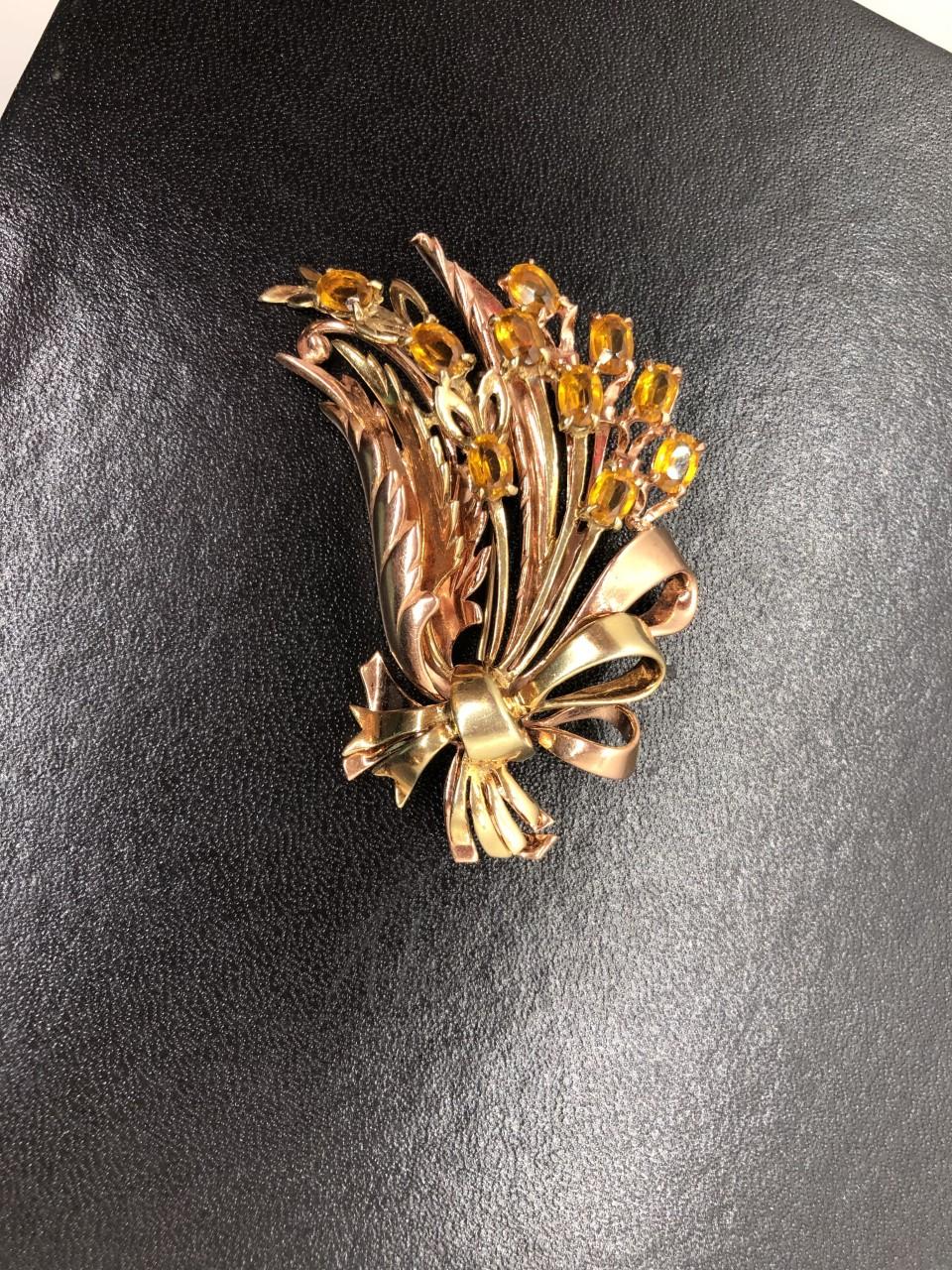 Circa 1940, 14k rose and yellow gold brooch, designed as a bow tied spray of citrine flowers, with matching earrings, signed R. DEROSA. Brooch, height 2 1/4 inches, total 40.9 grams