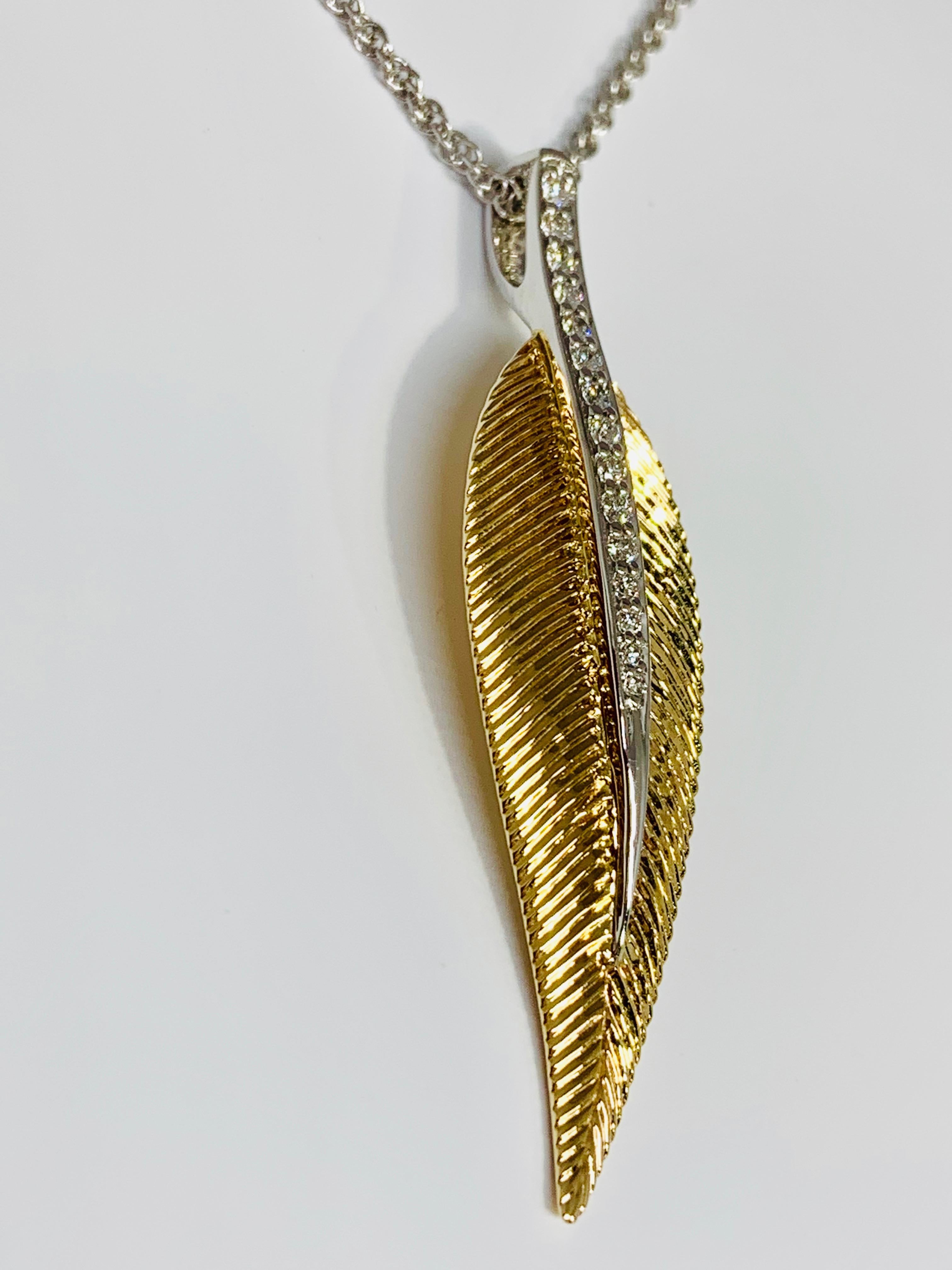 This beautiful textured leaf pendant from Allison-Kaufman Company features 0.15 carats of round diamonds. The two tone pendant includes an 18K white gold 18