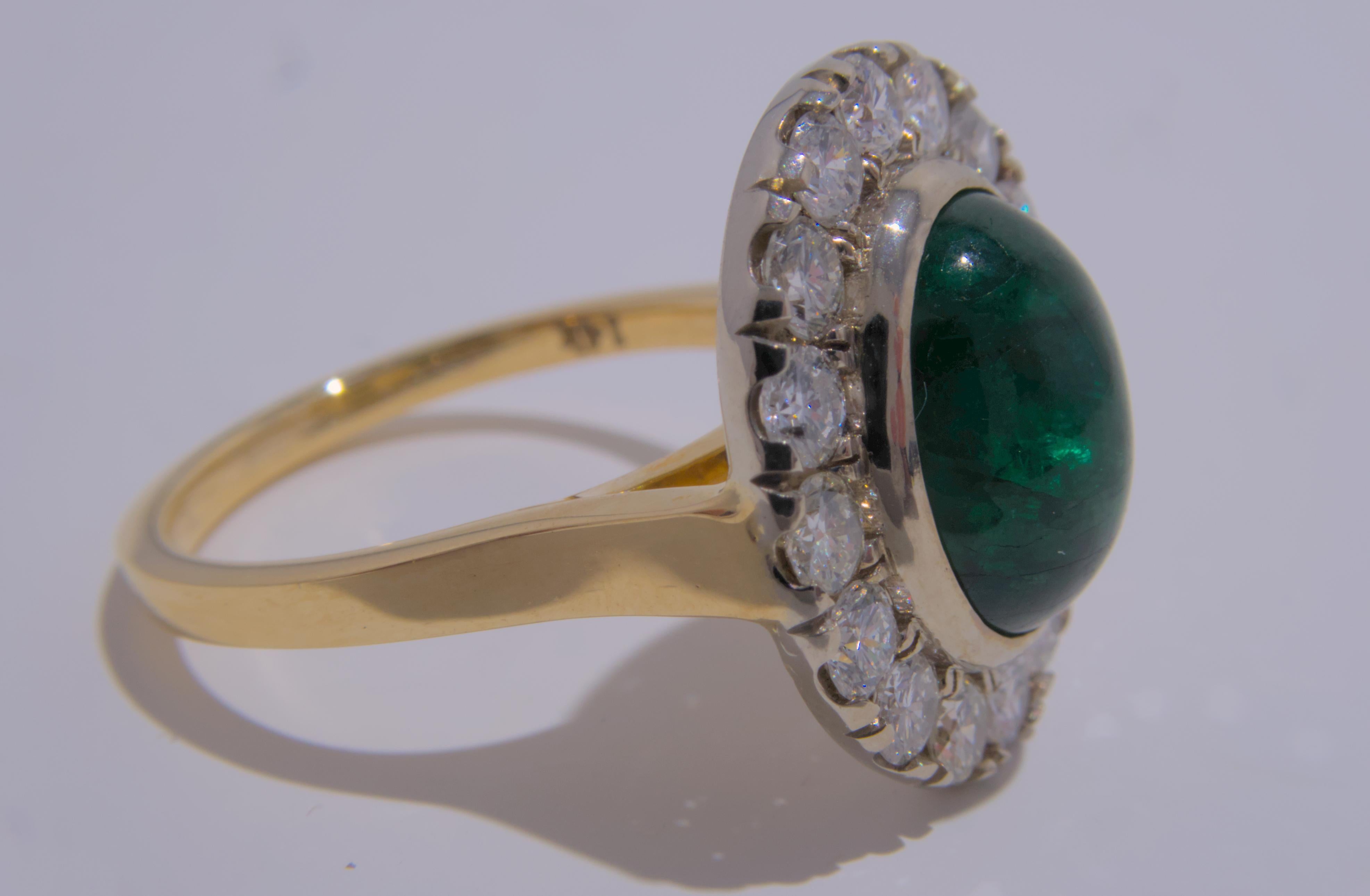 This elegant 14K gold ring showcases a stunning deep green cabochon emerald at its center, surrounded by 16 sparkling round diamonds. The emerald, with an estimated weight of 3.39 carats, is the perfect shade of green and adds a pop of color to the