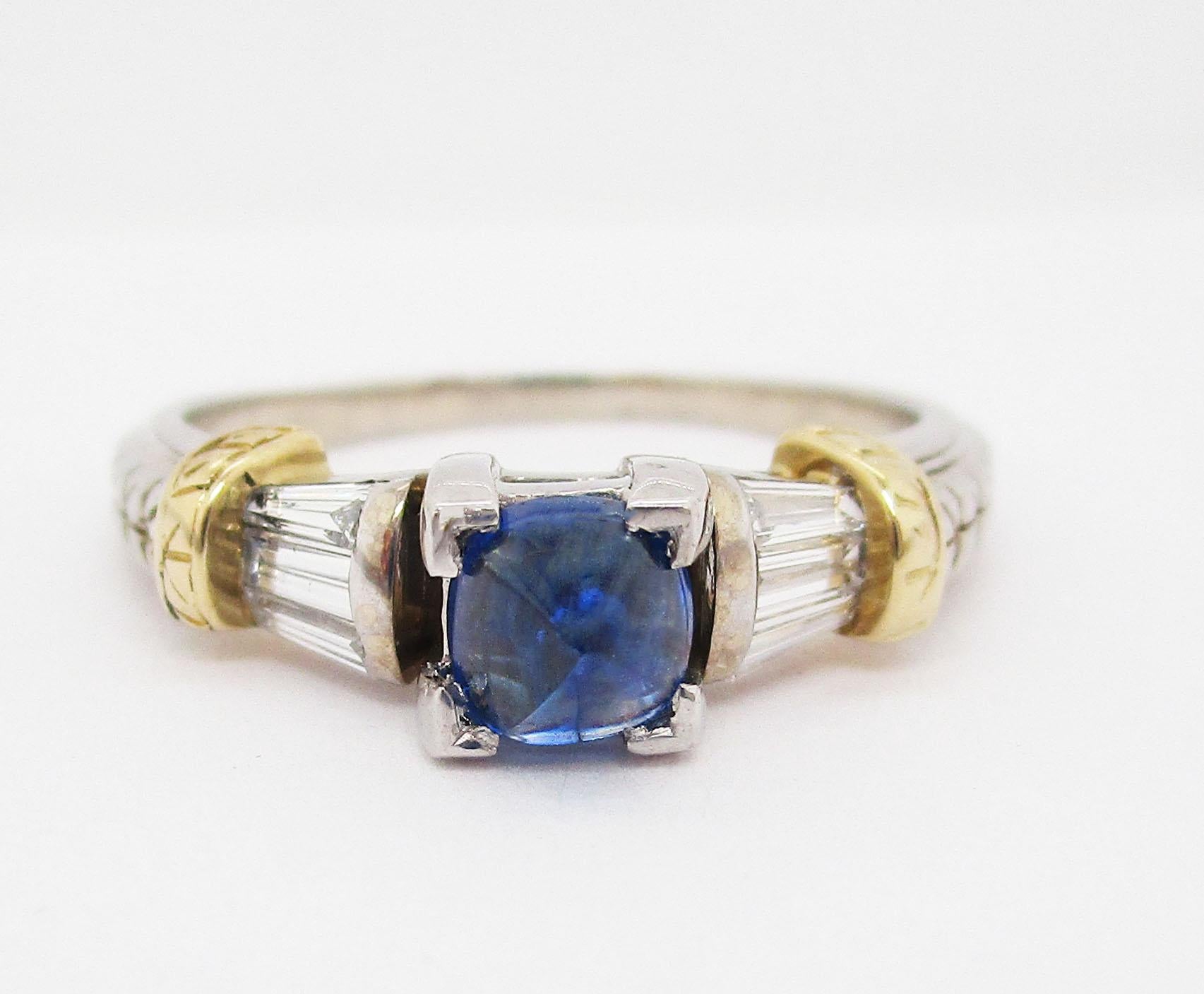 This remarkable ring combines both white and yellow 14k gold to frame stunning white baguette diamonds and a breathtaking natural blue sapphire! The white gold shank of the ring has a gorgeous engraved design that runs up the shoulders to create