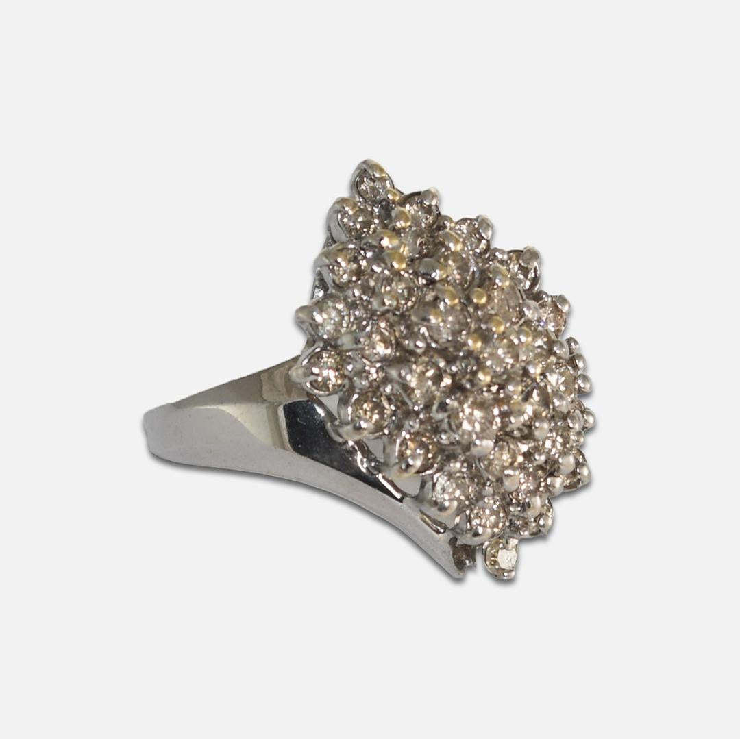 This cluster style 14 karat yellow and white weighs 6.65 grams.
It contains thirty-three round brilliant diamonds mounted
in a prong setting, with a total carat weight of 1.30.
The ring measures 1.0 inch in width and is a size 7.2.
It is in