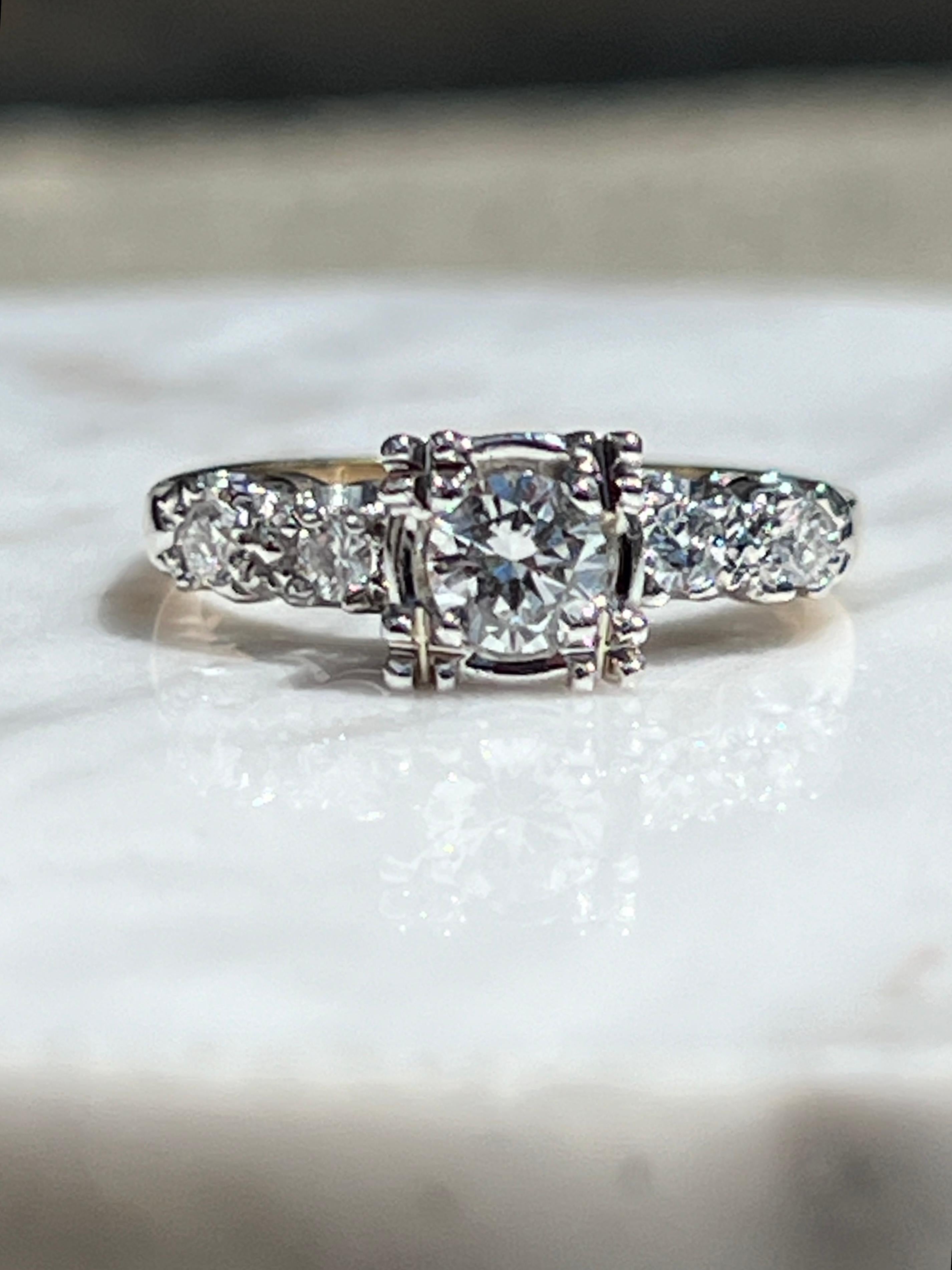 One 1940s 14 karat two-tone gold and diamond engagement ring. 
This ring features a beautiful illusion set transitional cut center stone with H color and VS1 clarity with a total carat weight of 0.33. The side stones are modern round brilliant