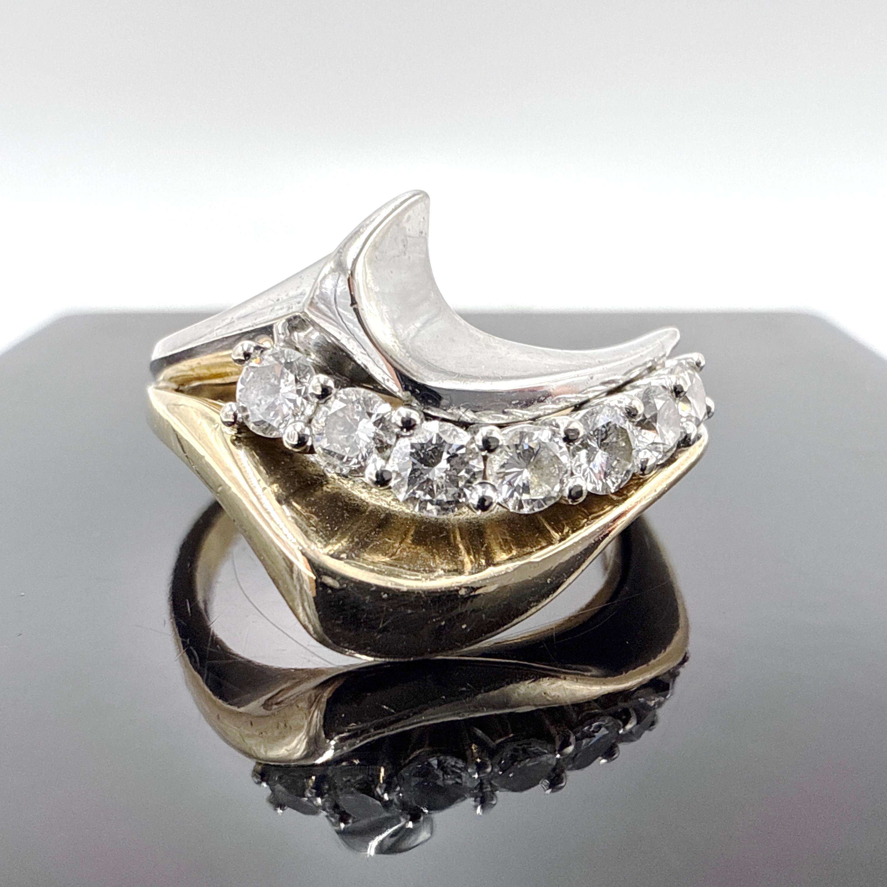Questo anello con diamante in oro 14K bicolore presenta un dinamico design a onda che combina elementi in oro giallo e bianco in una configurazione scultorea e curva. L'anello è fuso in cera, assemblato a mano e rifinito a lucido. La parte superiore