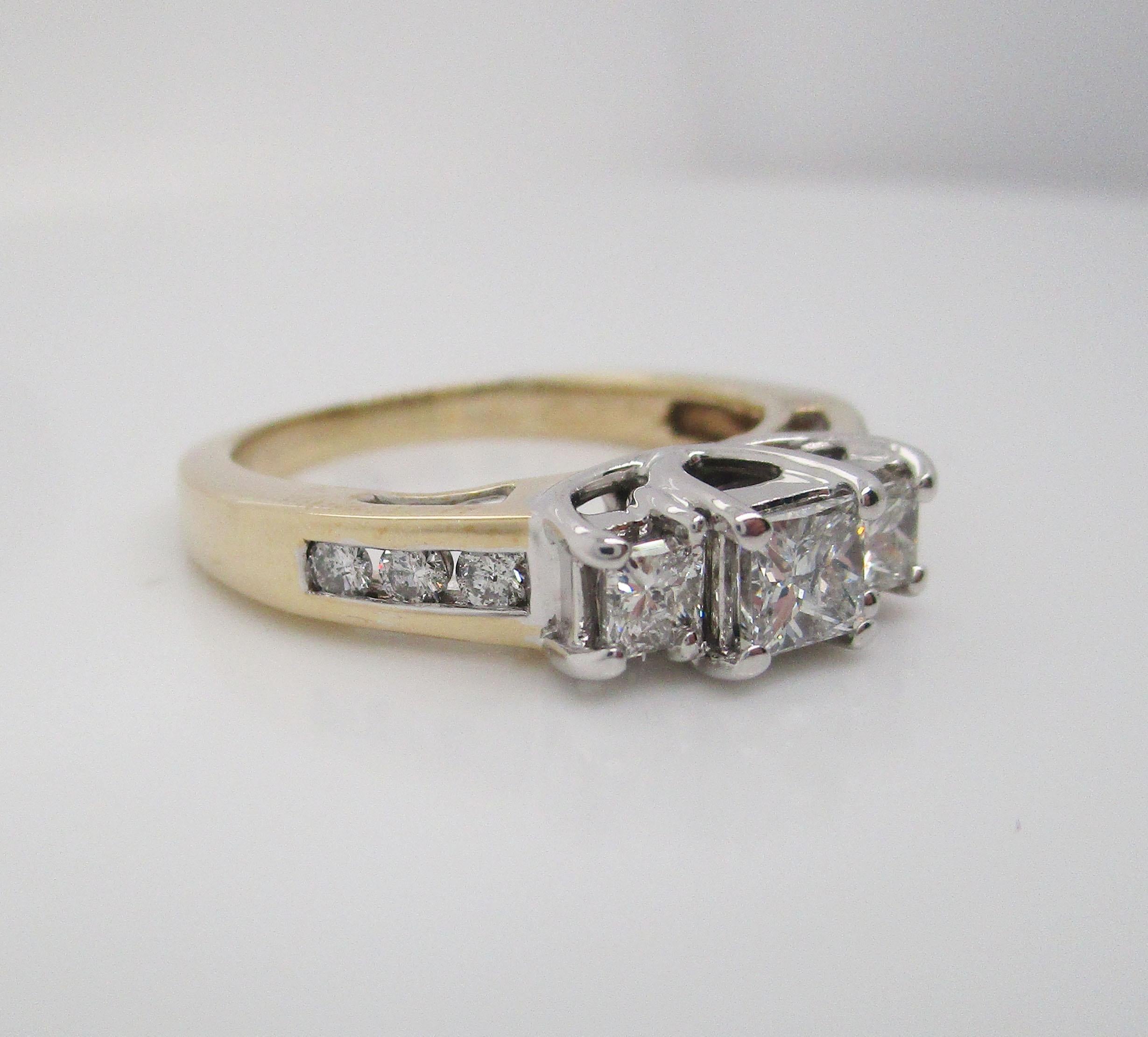 This is a beautiful diamond engagement ring in 14k yellow and white gold featuring three gorgeous princess cut diamonds! The ring is in 14k yellow gold, while the head is in 14k white gold and serves as the perfect complementary background to the