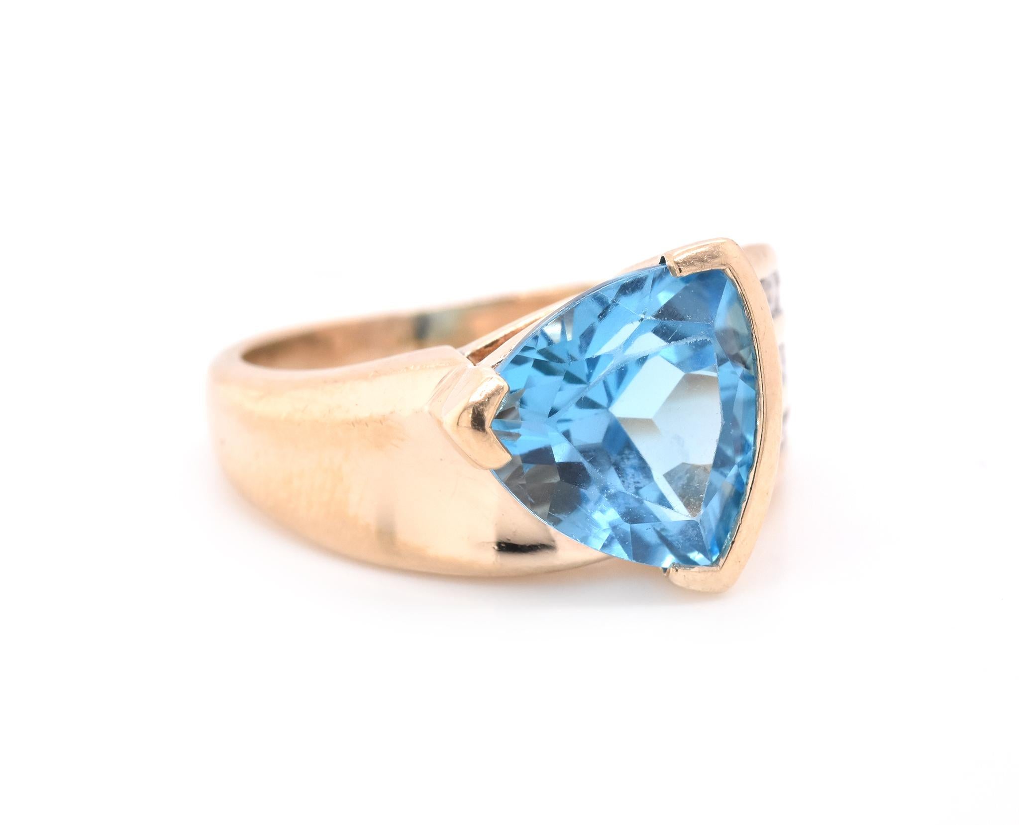 Material: 14k yellow gold
Gemstone: 1 Brilliant Trillion Cut Blue Topaz
Diamonds: 15 round brilliant cuts = 0.30cttw
Color: G
Clarity: SI2-I1
Ring Size: 5 ½  (allow up to two additional business days for sizing requests)
Dimensions: ring top