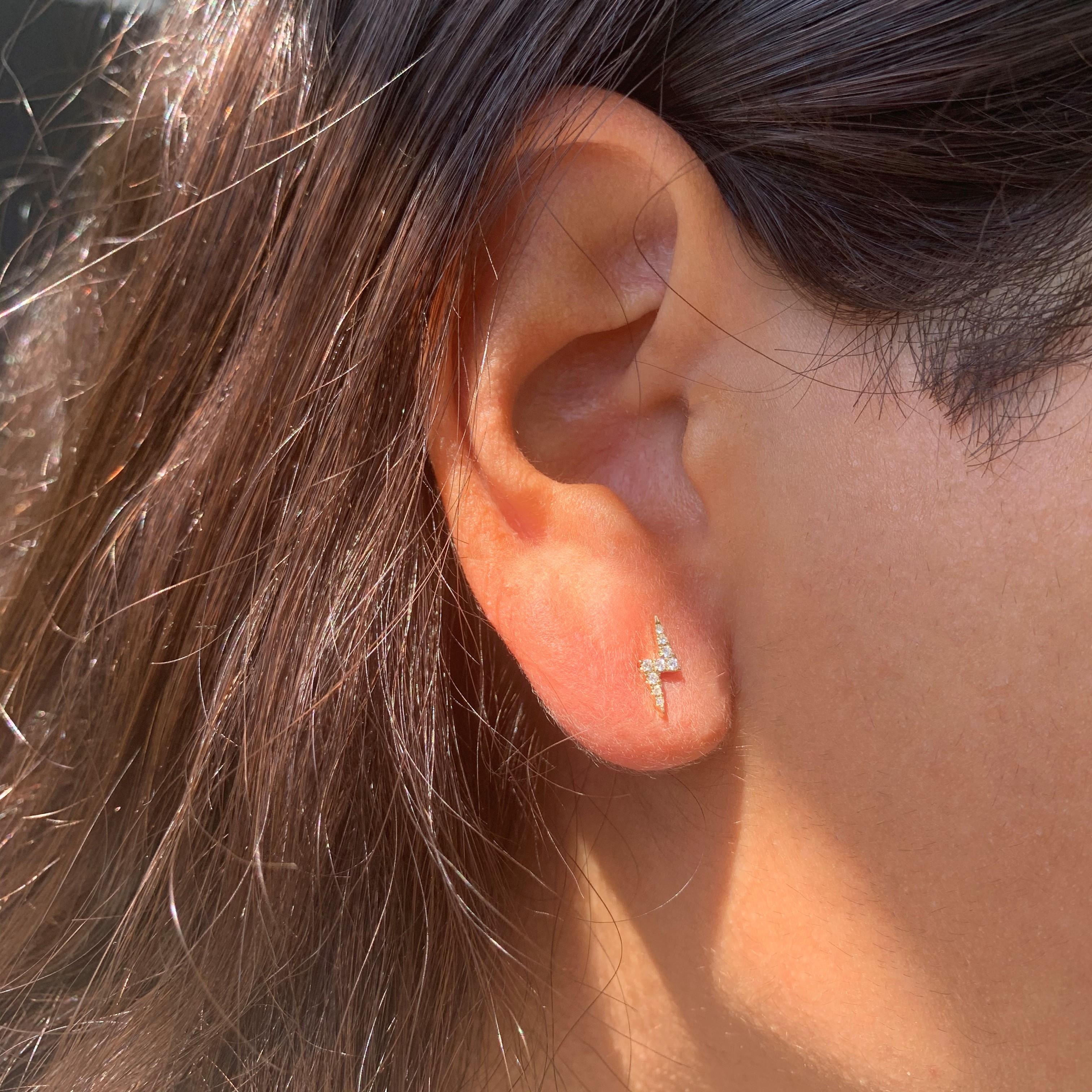 Zeigen Sie Ihren einzigartigen Stil mit diesen auffälligen Blitz-Ohrringen. Die Ohrringe sind aus 14 Karat Gold gefertigt und mit ca. 0,12 Karat natürlichen weißen Diamanten besetzt. Sie sind in Weiß-, Gelb- und Roségold erhältlich. Die Ohrringe