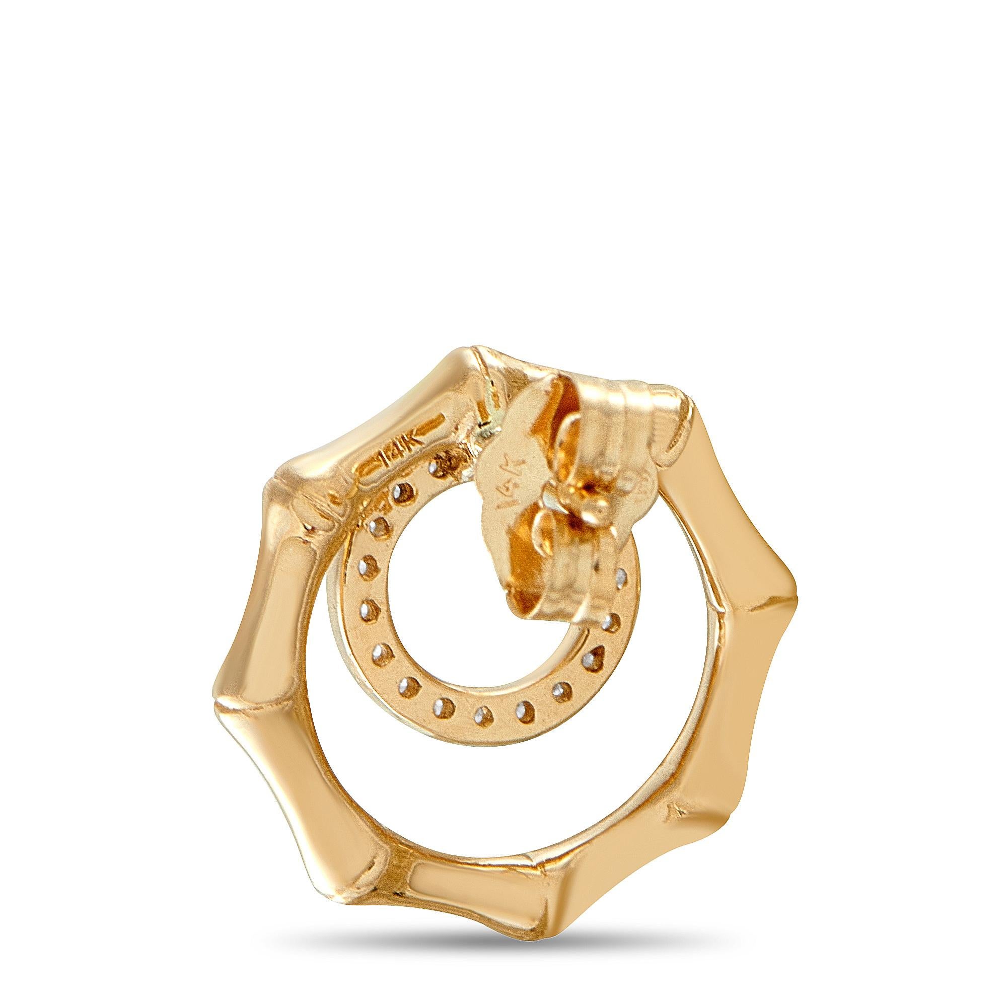 Minimal yet distinctive, these earrings make a quiet statement. They're crafted in 14K yellow gold and feature an off-centered, diamond-studded hoop. Surrounding this ring is a polished octagonal frame with a subtle bamboo-inspired detailing. The