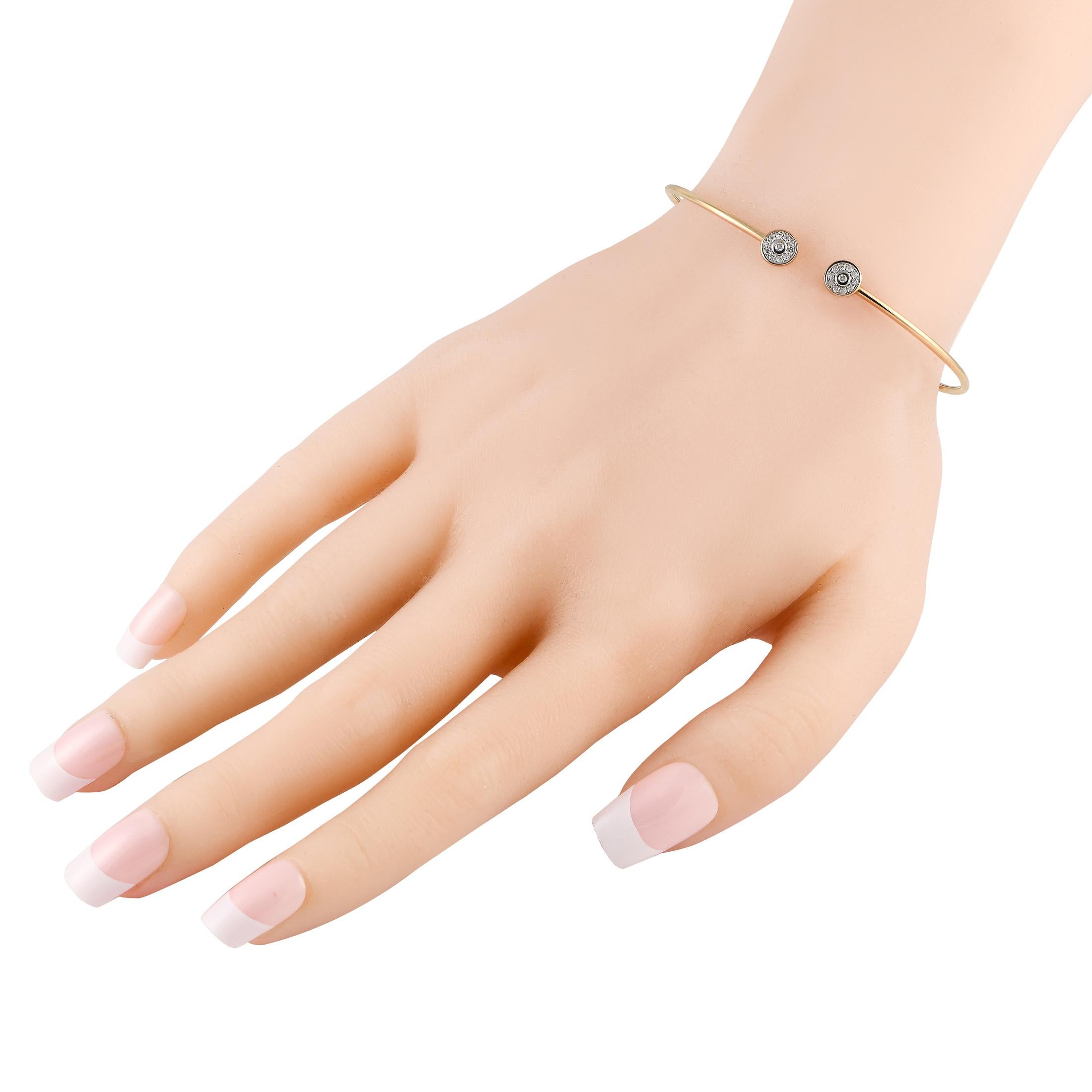 This ultra-slim cuff bangle makes the perfect embellishment for any outfit. It is crafted in durable 14K yellow gold and has its two ends punctuated by a bezel halo of tiny round diamonds. This lightweight bracelet goes with everything and has just