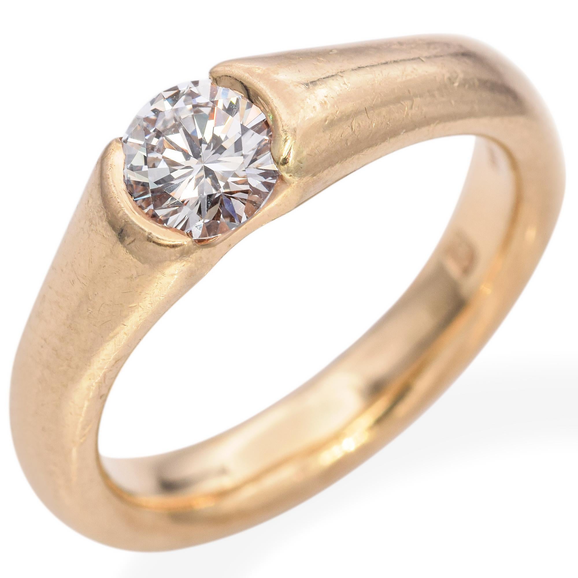 Une étude de la simplicité, de l'élégance et de la brillance. Cette bague de fiançailles contemporaine est ornée d'un superbe diamant blanc rond de 0,56 carat. La pierre est solidement nichée dans un élégant bracelet en or jaune 14k. Le design
