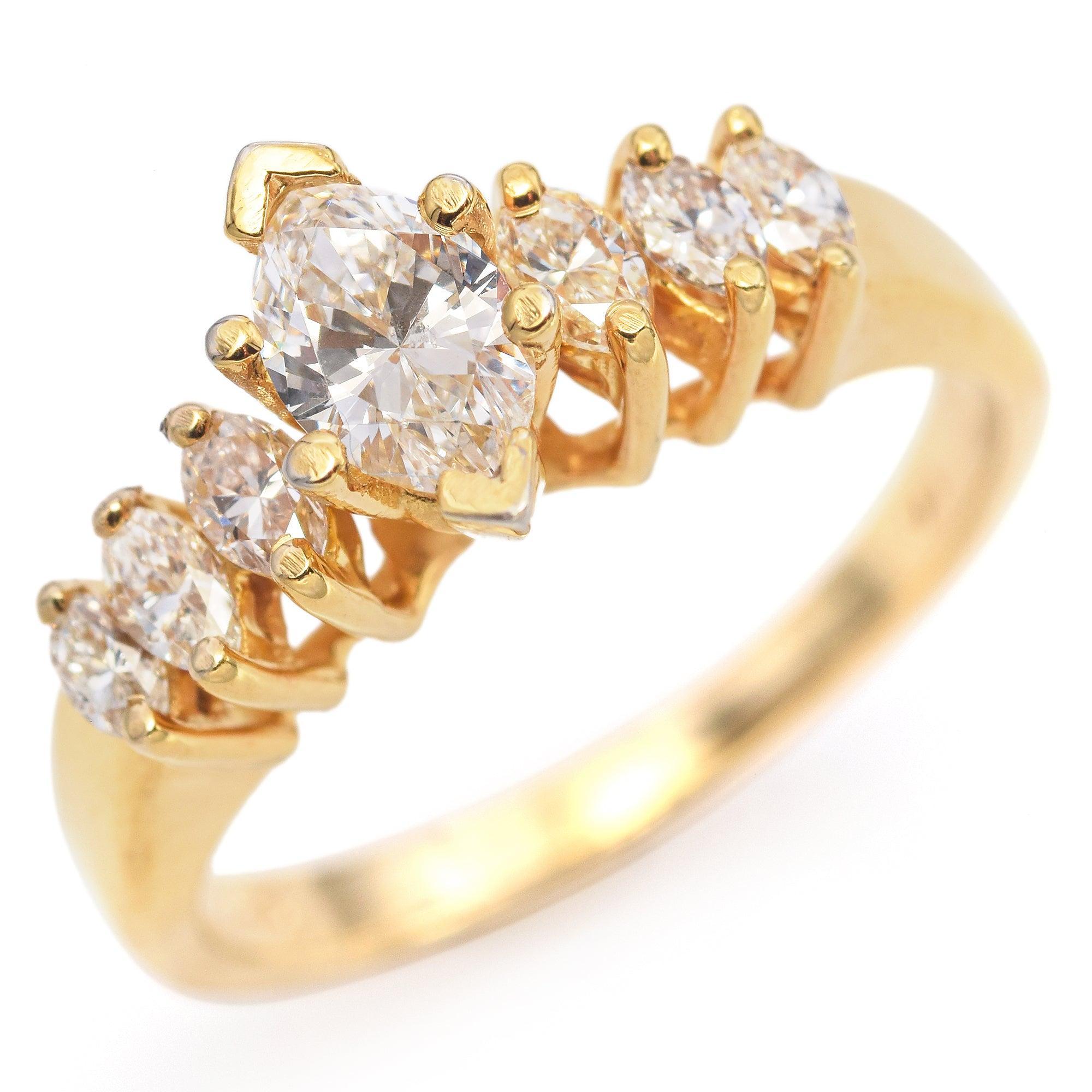 Questo elegante anello di fidanzamento è realizzato in oro giallo 14K e presenta al centro uno splendido diamante taglio marquise. Il diamante marquise è accentuato da una serie di diamanti laterali con taglio rotondo e marquise, creando un grazioso