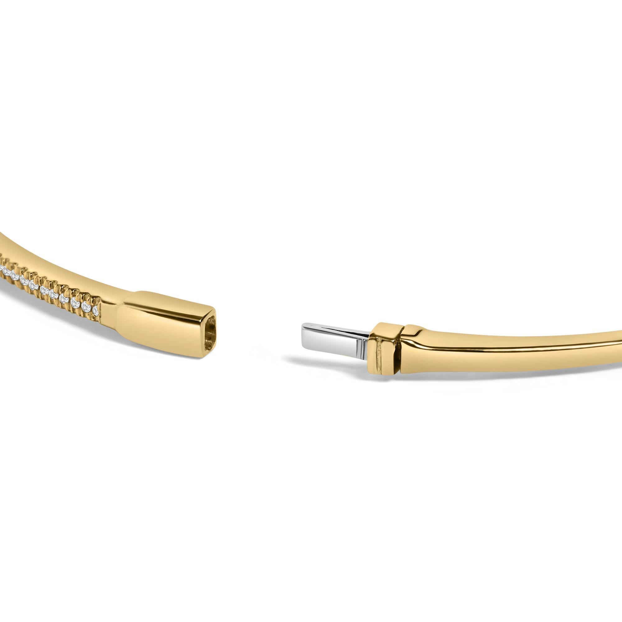 Immerse yourself in the delicate luxury of this 14K yellow gold bangle bracelet, where traditional elegance meets refined modernity. Each 1/3 carat of natural diamonds arrayed along the upper half sparkles with an understated brilliance, their I-J