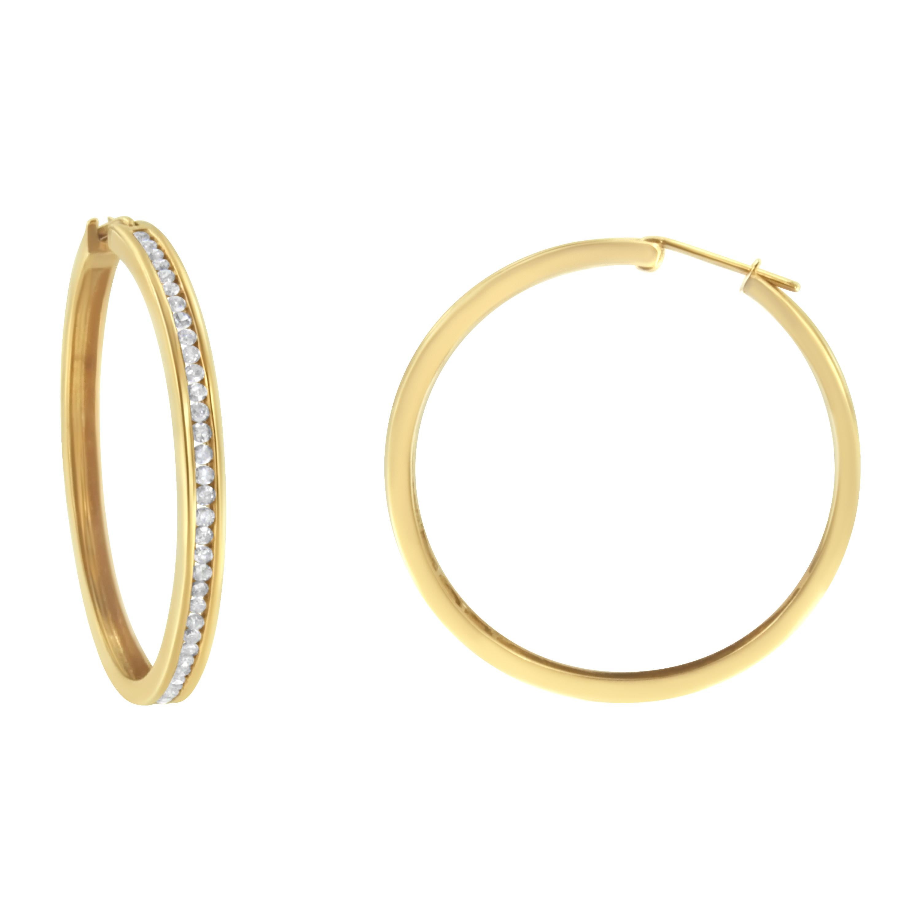 You can't go wrong with these classic 1ct TDW diamond hoop earrings. Sixty six channel set, round cut diamonds sparkle against the warm tone of this 14k yellow gold design. A clip on mechanism keeps the earrings secure. These natural diamonds are