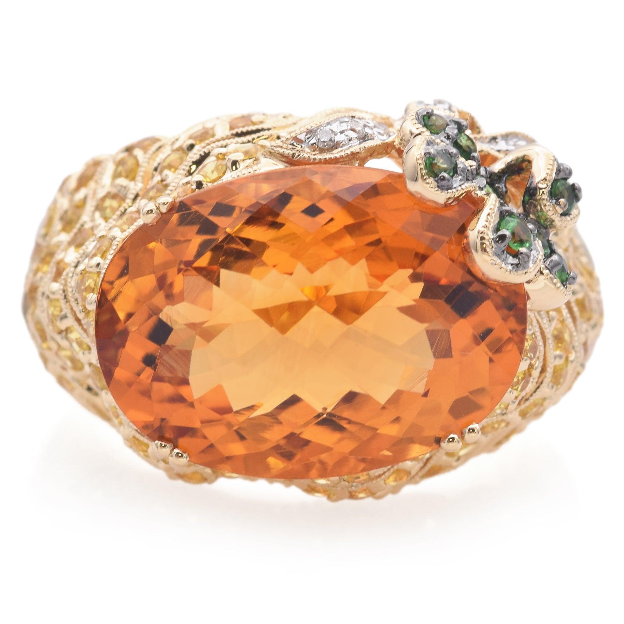 Cette audacieuse bague en or jaune 14 carats est ornée d'une superbe citrine ovale de 11 carats, qui rayonne de chaudes teintes dorées. Le design vibrant est rehaussé de pierres précieuses topaze et grenat richement colorées, créant un contraste