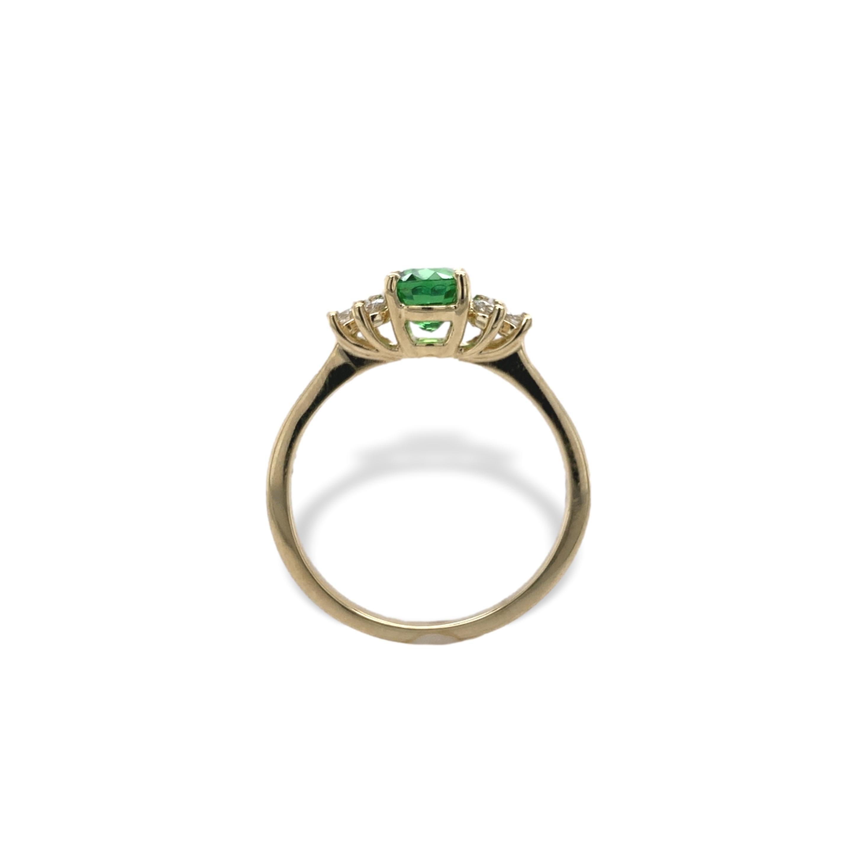14K yellow gold tsavorite green garnet and diamond ring. The tsavorite is a bright grass green color and weighs 1.11 carats. The oval stone measures about 6.7mm x 4.8mm. There are 6 round brilliant cut diamond accents measuring about 2mm and