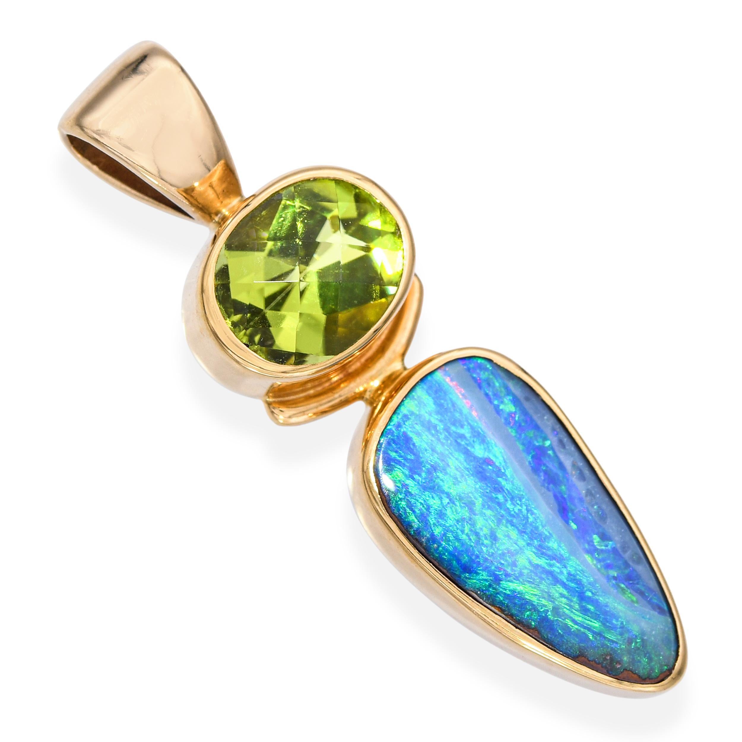 Ce pendentif vibrant est réalisé en or jaune 14 carats et présente une combinaison saisissante de pierres précieuses. Un péridot ovale facetté rayonne d'un vert éclatant au-dessus d'une opale de roche hypnotique, animée d'éclats de bleu et de vert