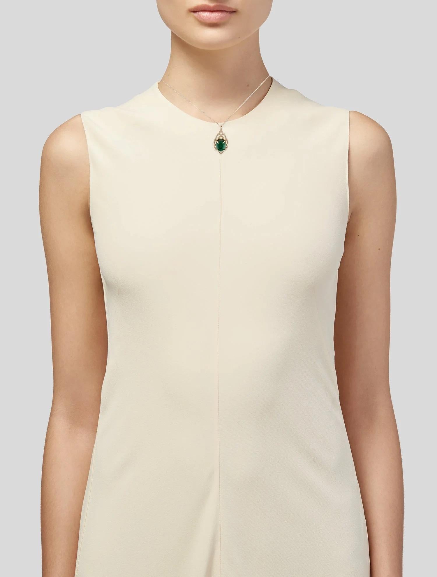 Ajoutez une touche de sophistication intemporelle à votre collection de bijoux avec ce collier pendentif en or jaune 14 carats orné d'émeraudes et de diamants. Doté d'une superbe émeraude cabochon ovale de 12,77 carats en guise de pièce maîtresse,