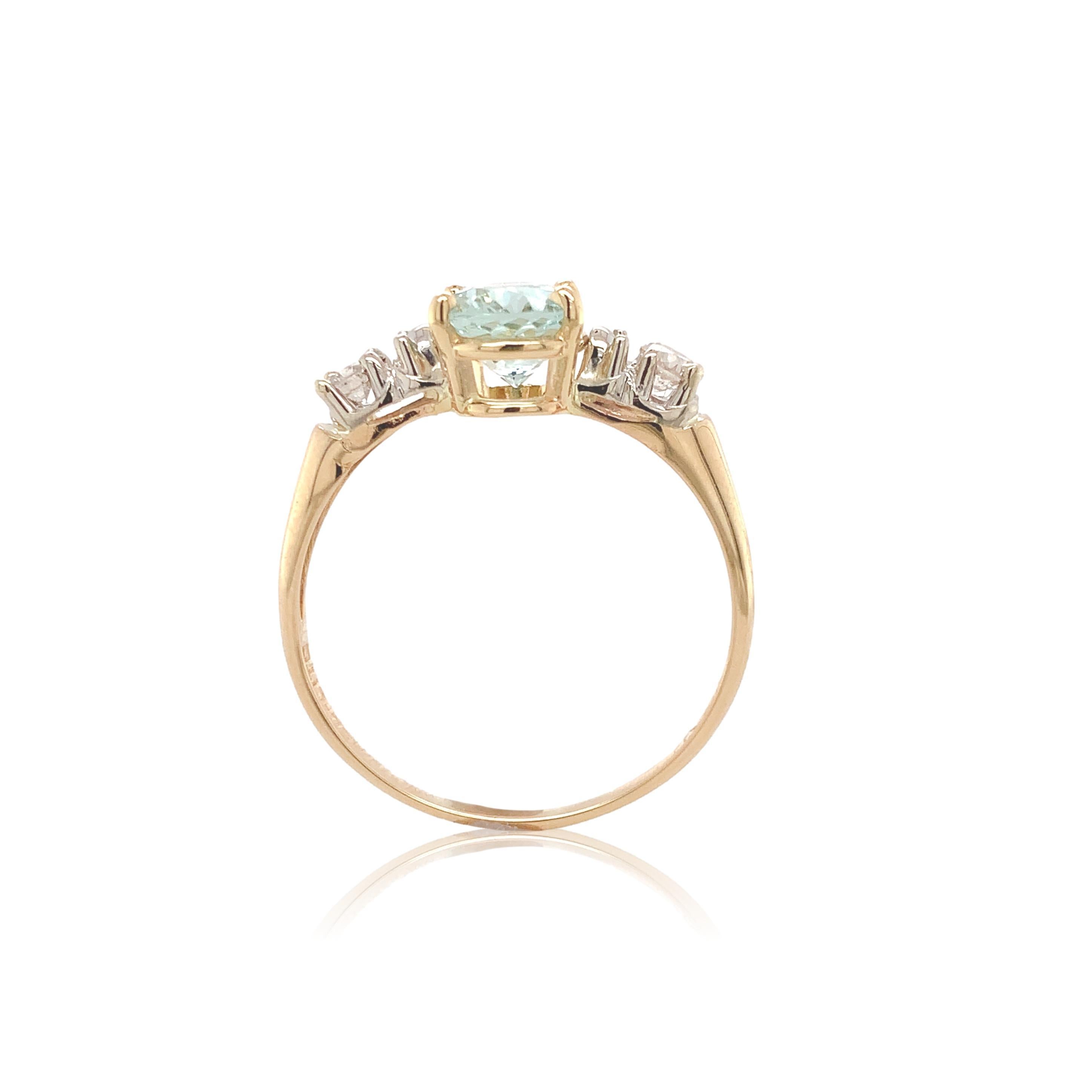 Ring aus 14 Karat Gelbgold mit Weißgoldakzenten und einem ovalen Aquamarin von 1,31 Karat. Der hell grünlich-blaue Aqua misst etwa 8,4 mm x 6,2 mm.  Es gibt 2 runde Brillantschliff Diamanten Akzente messen etwa 2,8 mm und einem Gewicht von etwa