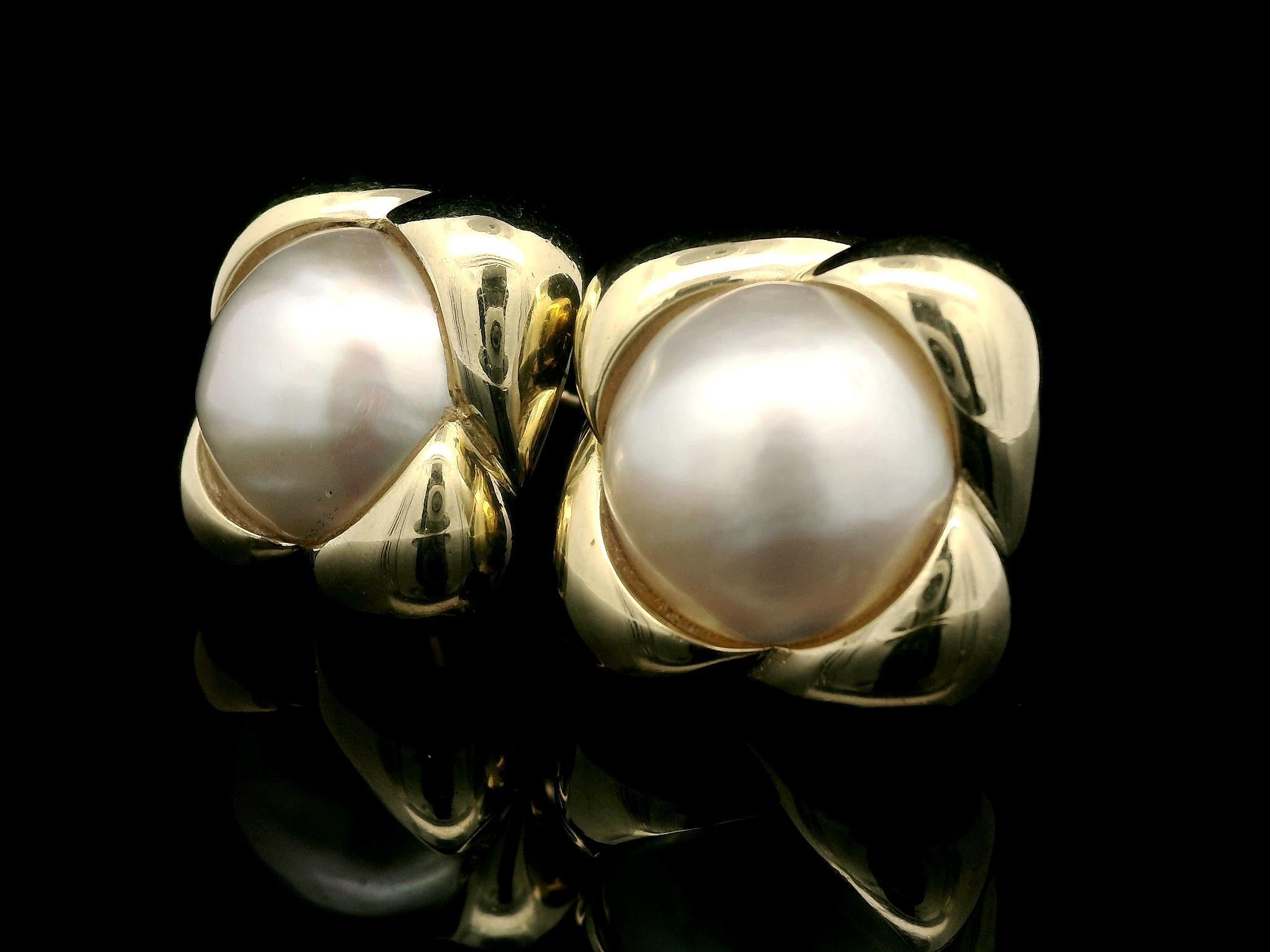 --Pietre: --
(2) Autentiche perle coltivate Mabe - Forma rotonda - Incastonate - Bel colore Whiting con sfumature rosa - Bella lucentezza - Alta qualità - 14,2 mm ciascuna (circa)

Materiale: Oro giallo massiccio 14k
Peso del materiale: 22.34