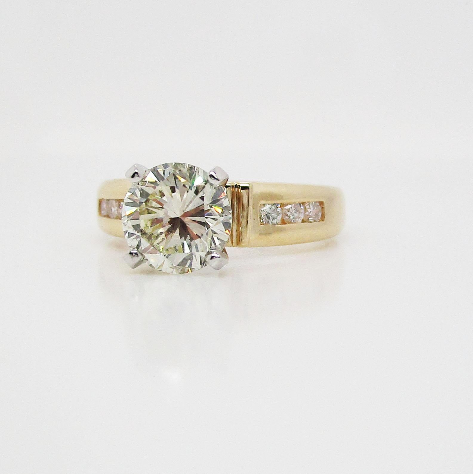This is an absolutely stunning diamond engagement ring in 14k yellow gold with a breathtaking diamond center stone! This is a truly gorgeous diamond in a beautiful, traditional mounting. The center stone is flanked on either side by three delicate
