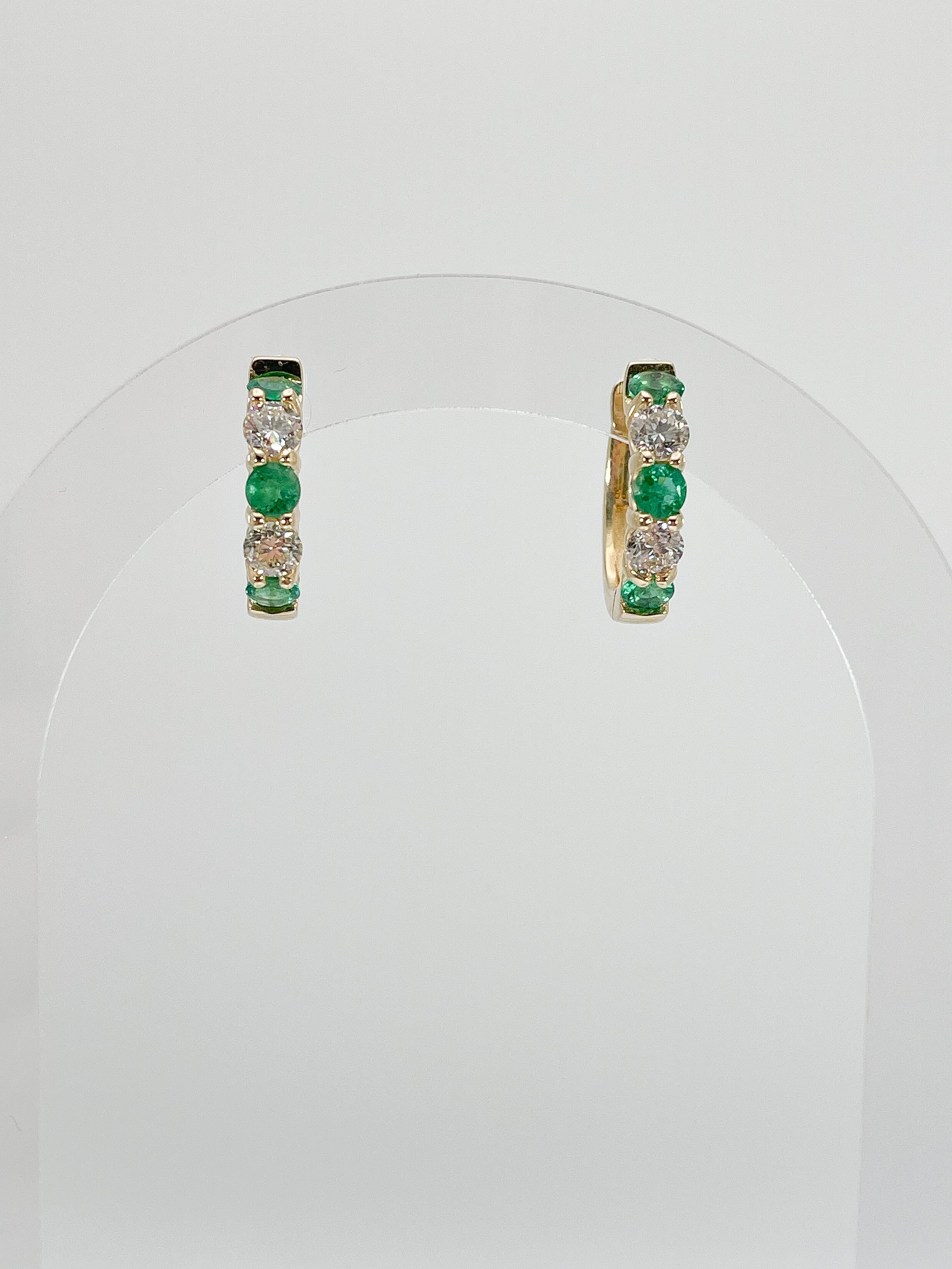 14k yellow gold 1.54 CTW emerald and 1.20 CTW diamond hoop earrings. The stones in these earrings are round, the measurements are 17.9 x 19.4, and they have a total weight of 6.26 grams. 